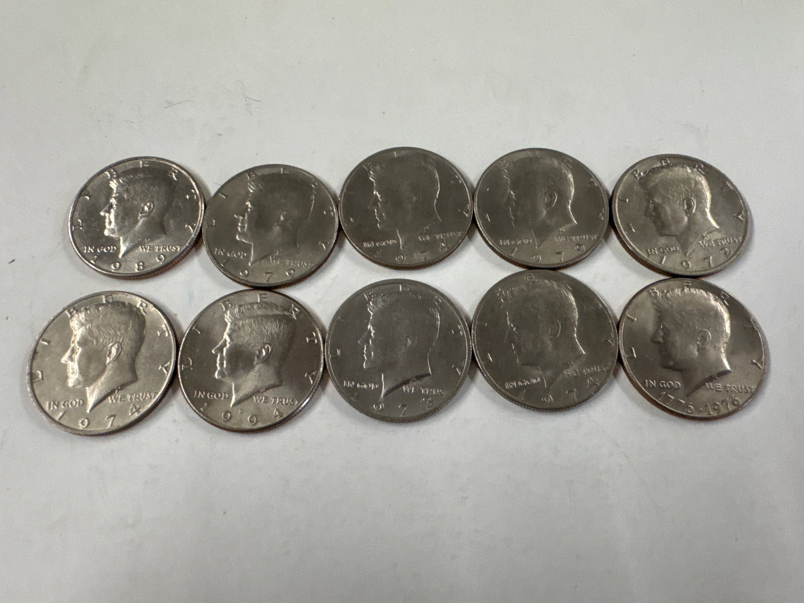 Collection of 10 Kennedy Half Dollar Coins: This lot features a collection of ten Kennedy Half Dollar coins. The obverse of each coin displays a profile of John F. Kennedy, while the reverse features the Presidential Seal. 