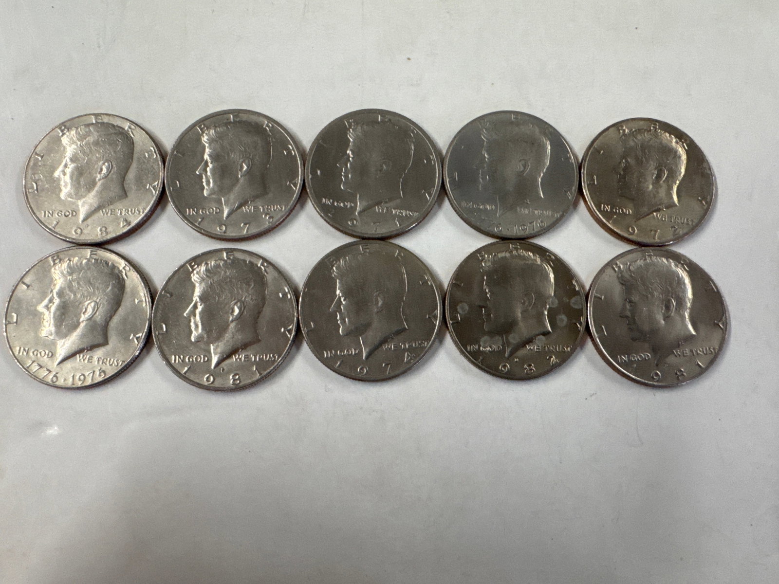 Collection of 10 Kennedy Half Dollar Coins: This lot features a collection of ten Kennedy Half Dollar coins. The obverse displays the profile of John F. Kennedy, while the reverse showcases the Presidential Seal. 