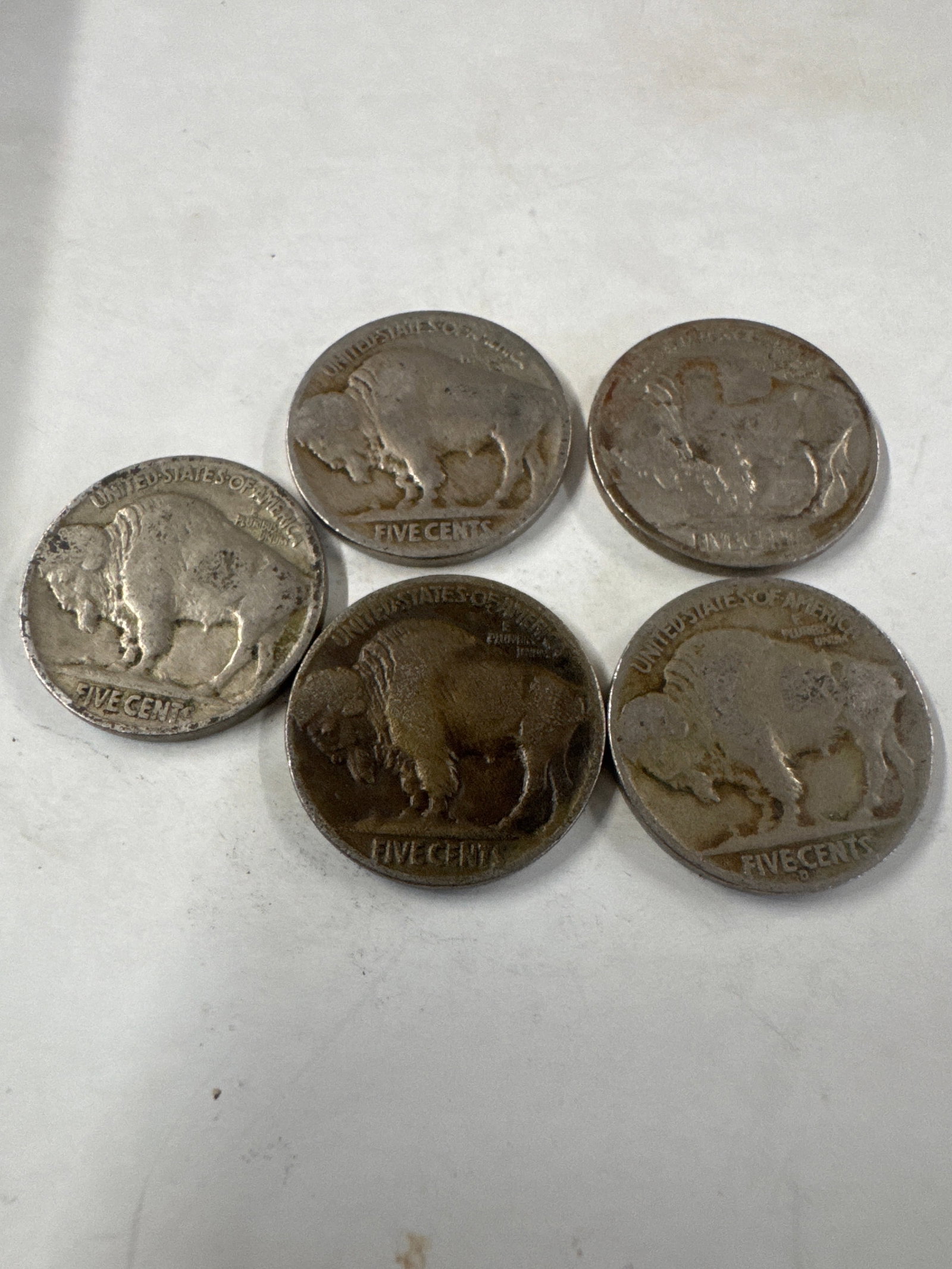 Collection of Five Buffalo Nickel Coins (233): A collection of five Buffalo nickel coins, also known as the Indian Head nickel. These coins feature a profile of an American bison on the reverse and a Native American on the obverse. The coins show 