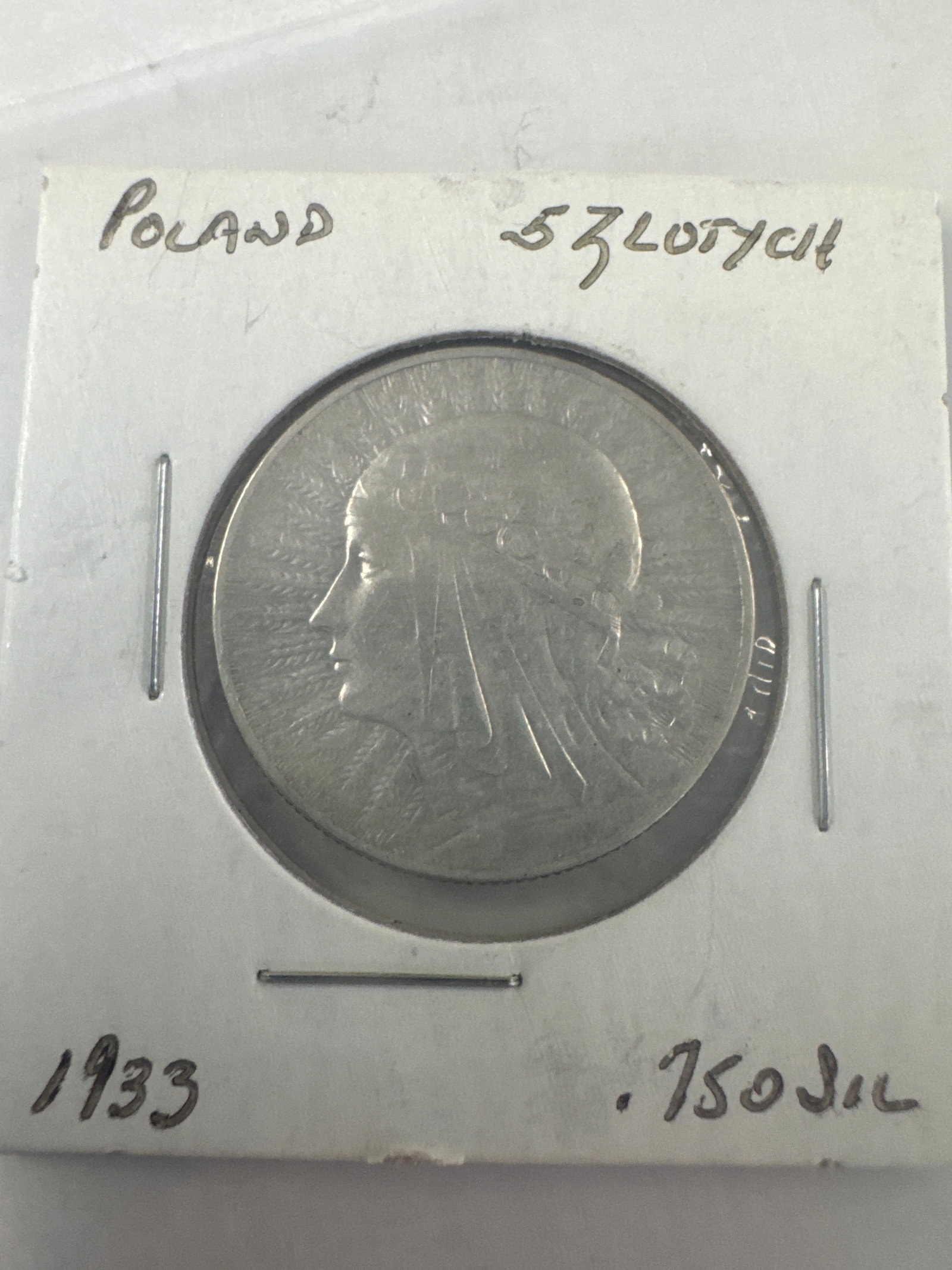 1933 Poland 5 Zlotych Coin: A silver coin from Poland dated 1933, featuring a profile of a woman on one side and an eagle crest on the other. Silver .750.