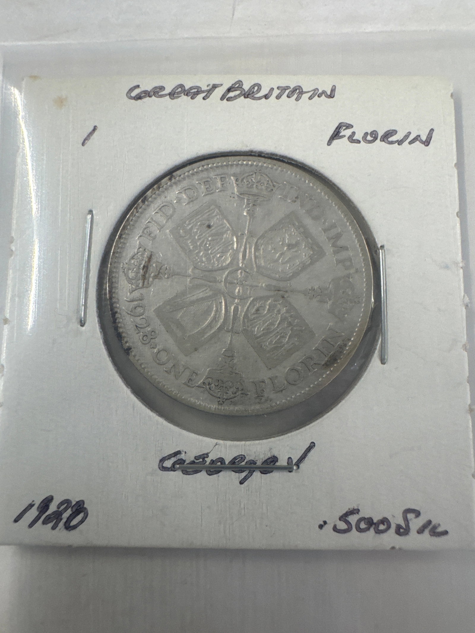 1928 Great Britain 1 Florin Coin: A silver coin from Great Britain, dated 1928, identified as a Florin. The obverse features a profile of King George V, and the reverse displays a cruciform shield with the inscription 'ONE FLORIN&