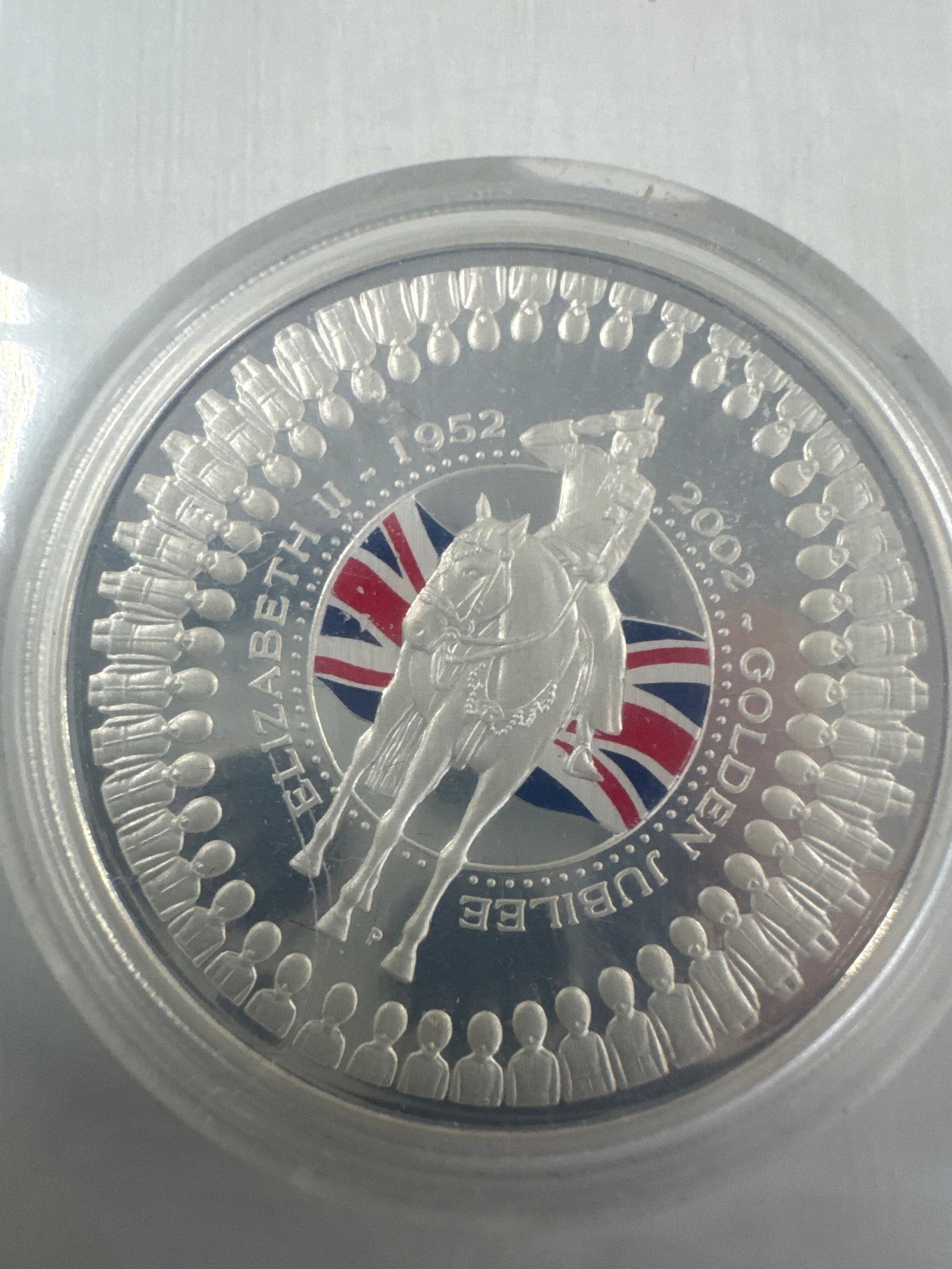 2002 Australia Elizabeth II Golden Jubilee 1 Dollar Silver Coin: This is a 2002 Australian one dollar silver coin commemorating the Golden Jubilee of Queen Elizabeth II. The obverse features a portrait of Queen Elizabeth II, and the reverse depicts a royal figure o