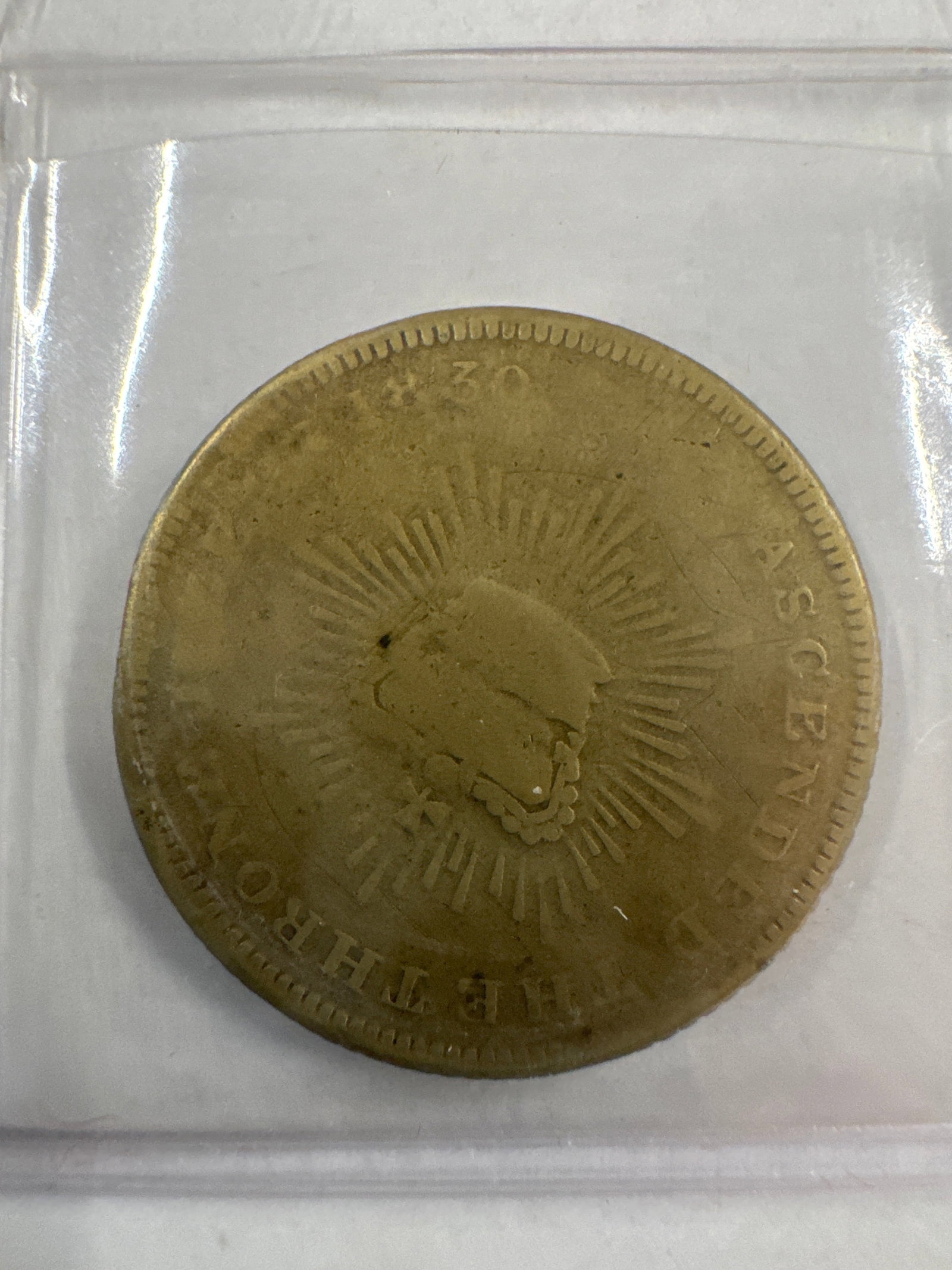 1830 King William IV and Queen Adelaide Coin: A brass coin featuring portraits of King William IV and Queen Adelaide on one side, and a radiant sunburst design with text on the other. The coin appears to be from 1830.
