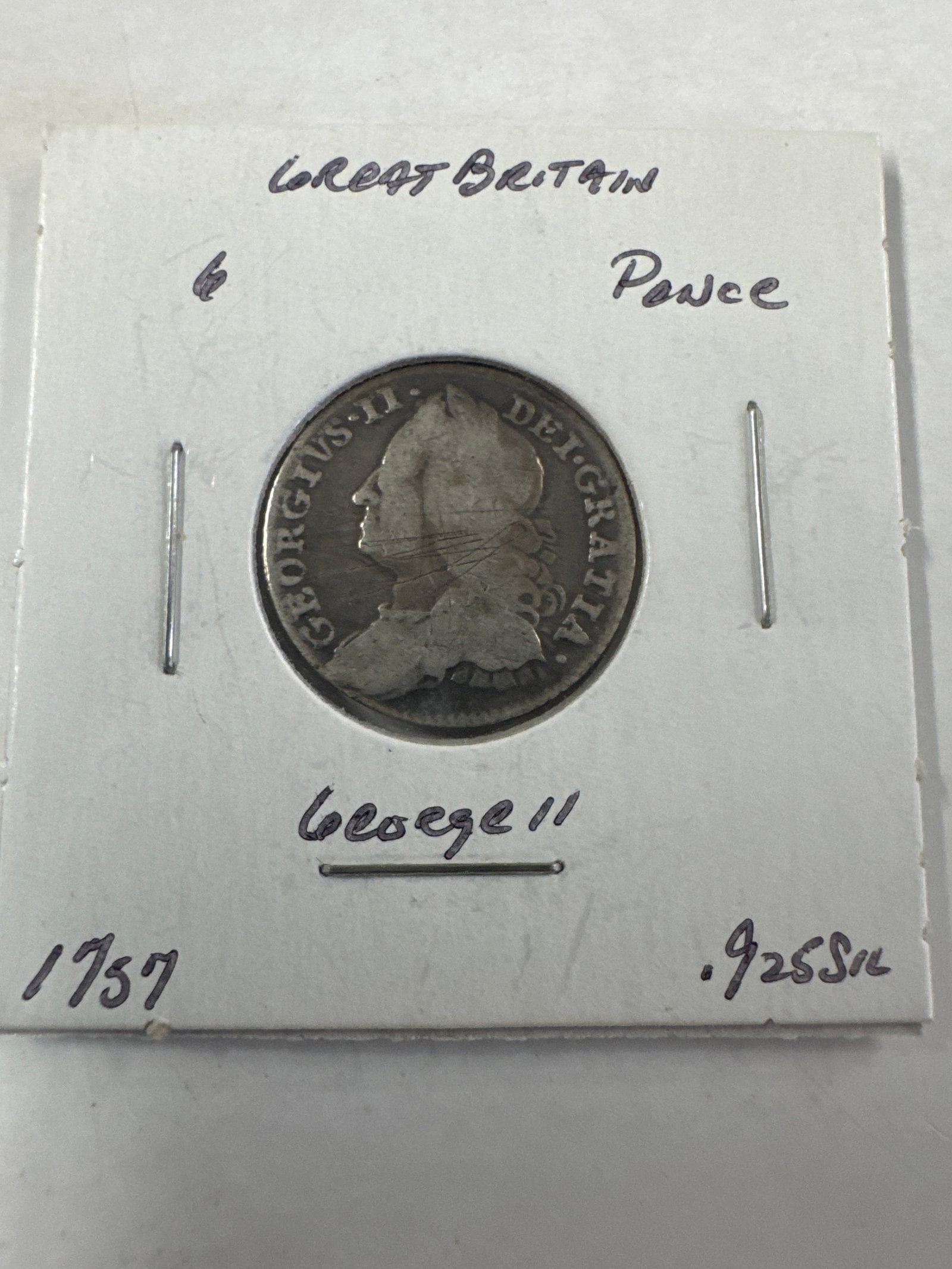 Great Britain 1757 George II Silver Sixpence Coin: A silver sixpence coin from Great Britain, dated 1757, featuring a profile of King George II on the obverse and a shield design on the reverse. The coin is .925 silver.