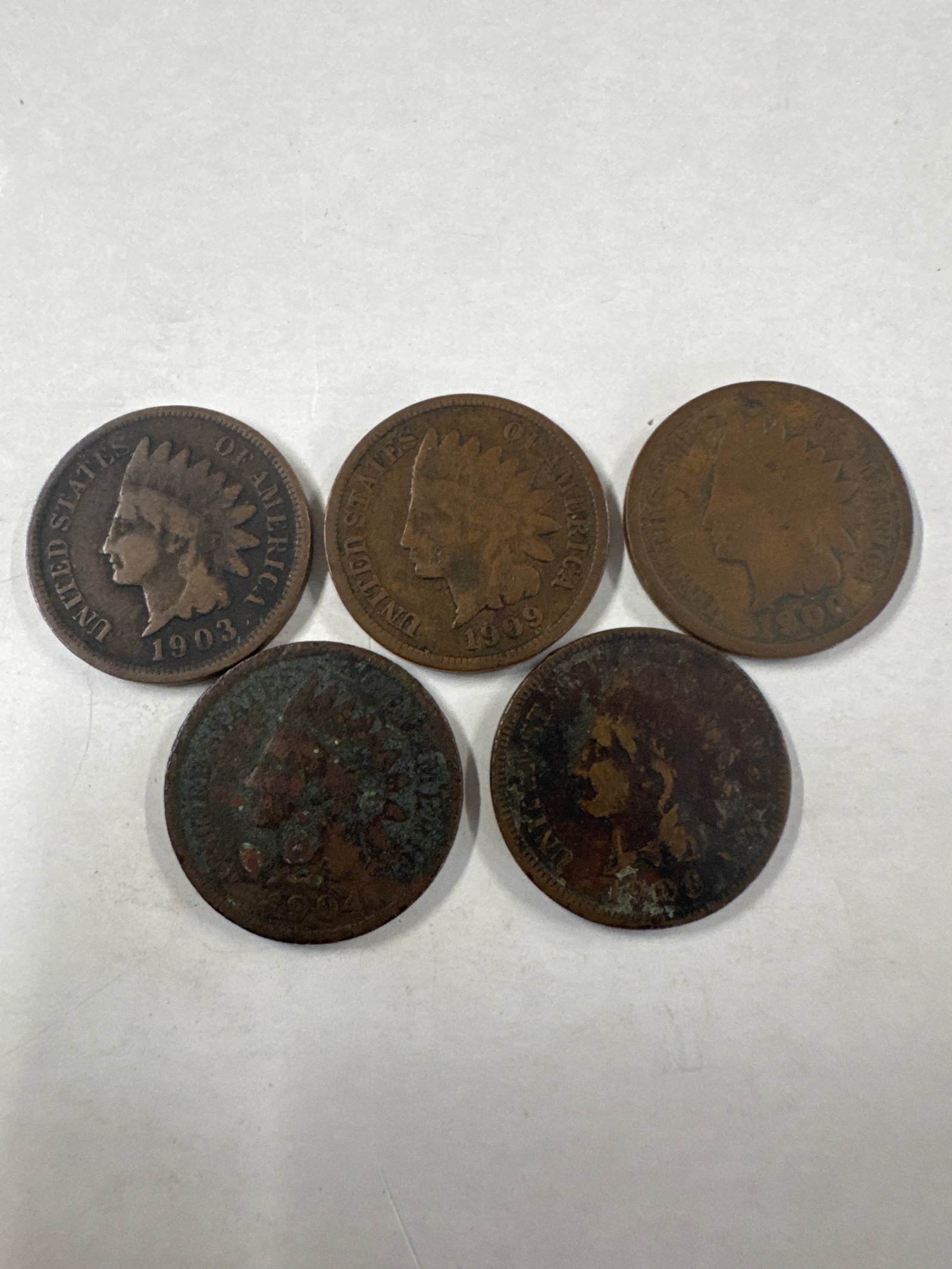 Collection of Five Indian Head Pennies: This lot features five Indian Head pennies. The coins show varying degrees of wear and patina, consistent with their age.