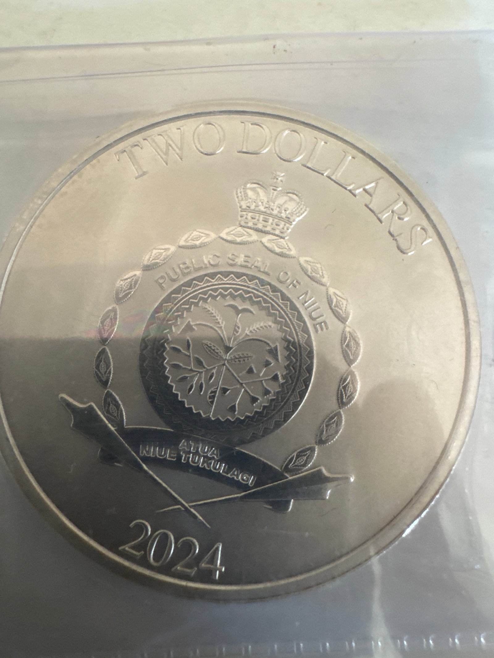 Niue 2024 Two Dollars "The Child" Star Wars Silver Coin: This is a 2024 Niue Two Dollars coin featuring "The Child" (Grogu) from Star Wars. The obverse displays the Public Seal of Niue and the year 2024. The reverse features "The Child" 