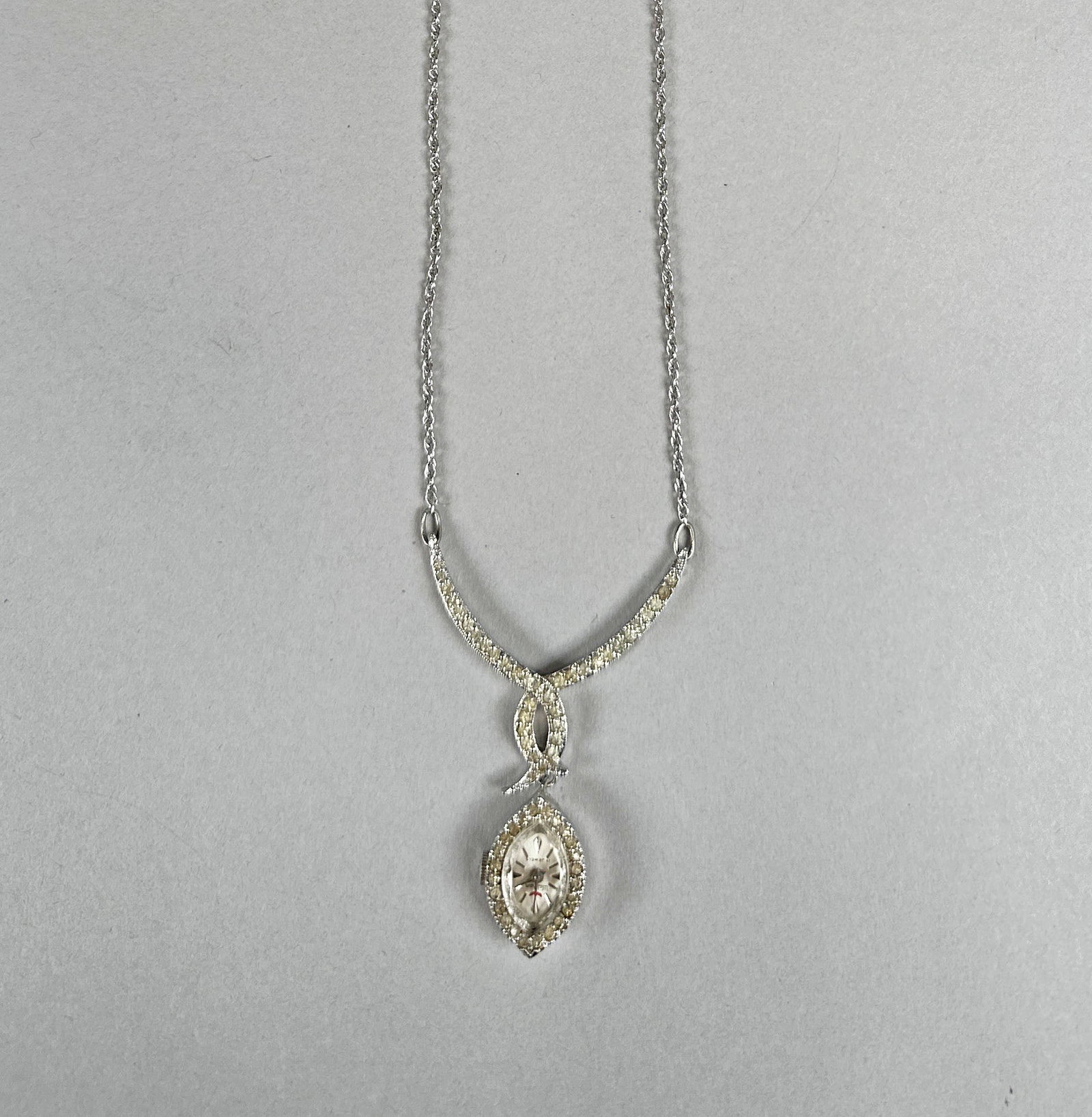 Vintage Waltham Watch Pendant Necklace: This exquisite vintage necklace features a delicate 14K white gold chain leading to a stunning pendant. The pendant is designed as a marquise-shaped watch case, encrusted with sparkling diamonds, and 
