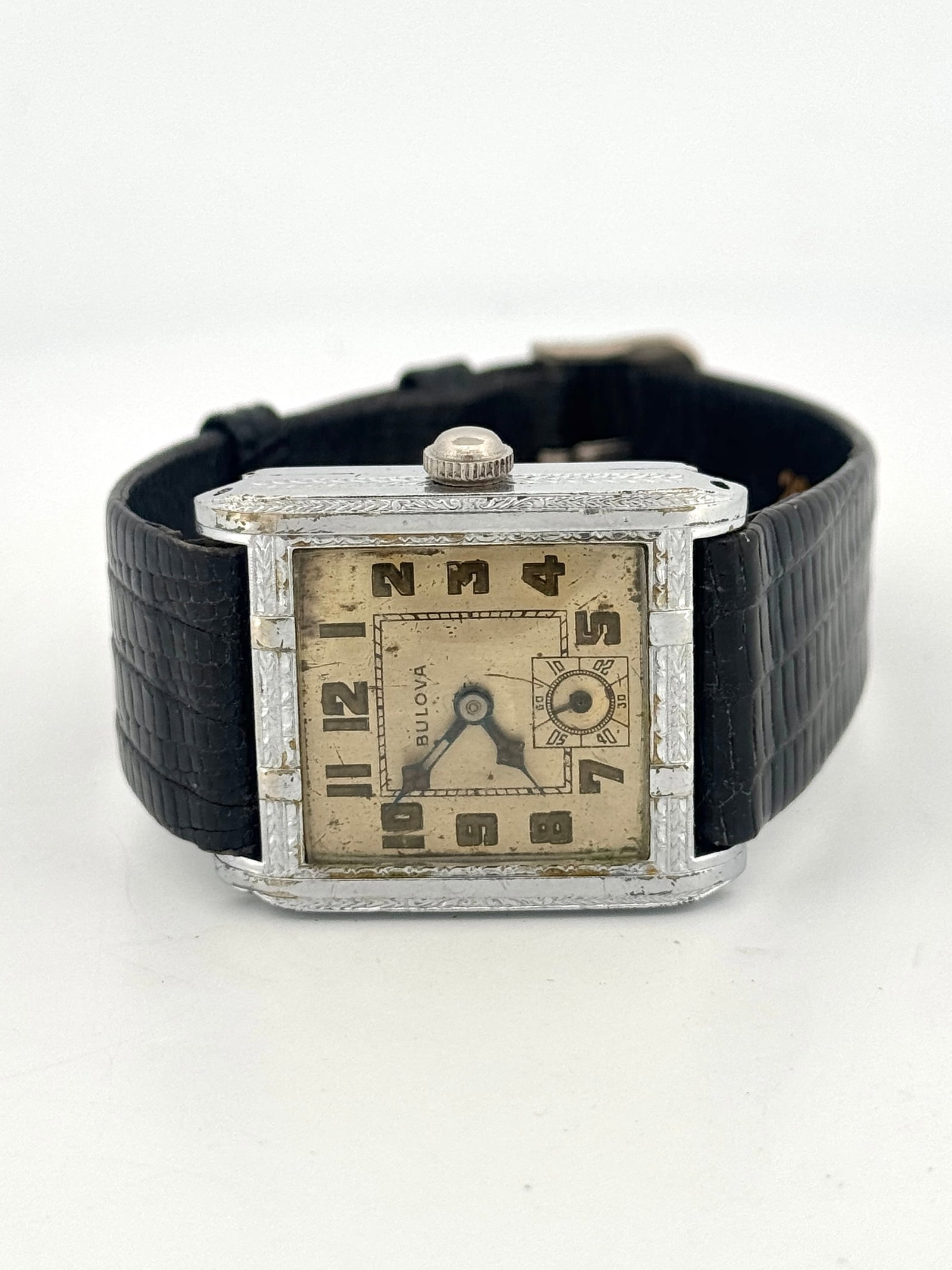 Vintage Bulova Art Deco Wristwatch: Vintage Bulova wristwatch featuring an Art Deco design. The watch has a square face with Arabic numerals and a subsidiary seconds dial. It is fitted with a black leather strap.