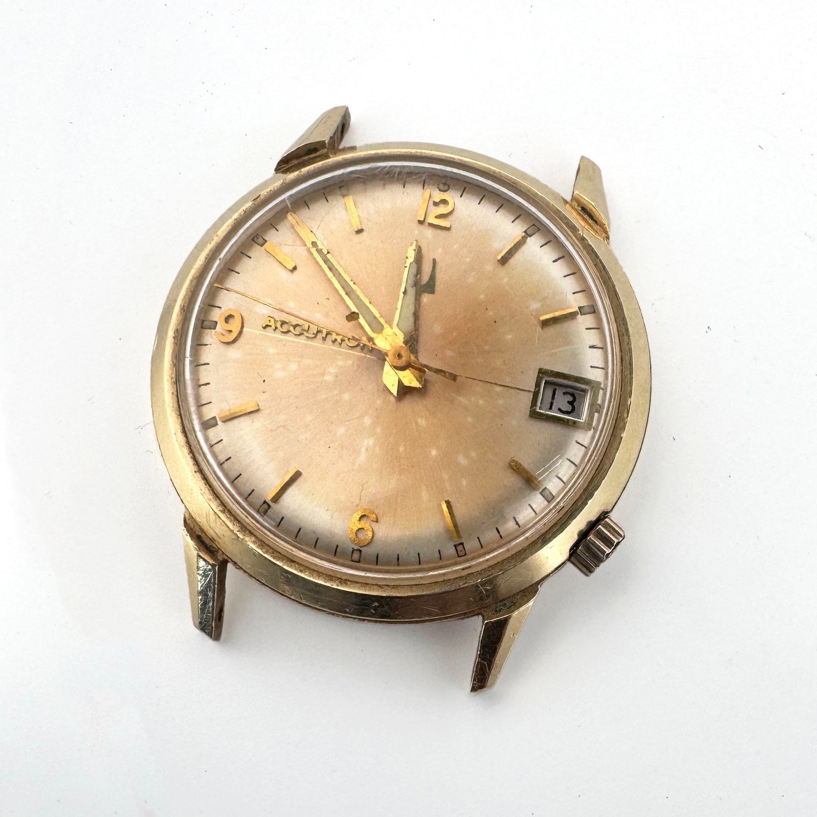 Bulova Accutron 14K Gold Filled Case Watch: This vintage Bulova Accutron watch features a 14K gold filled case and a champagne dial with a date complication. The movement is visible, showing the characteristic tuning fork of Accutron technology