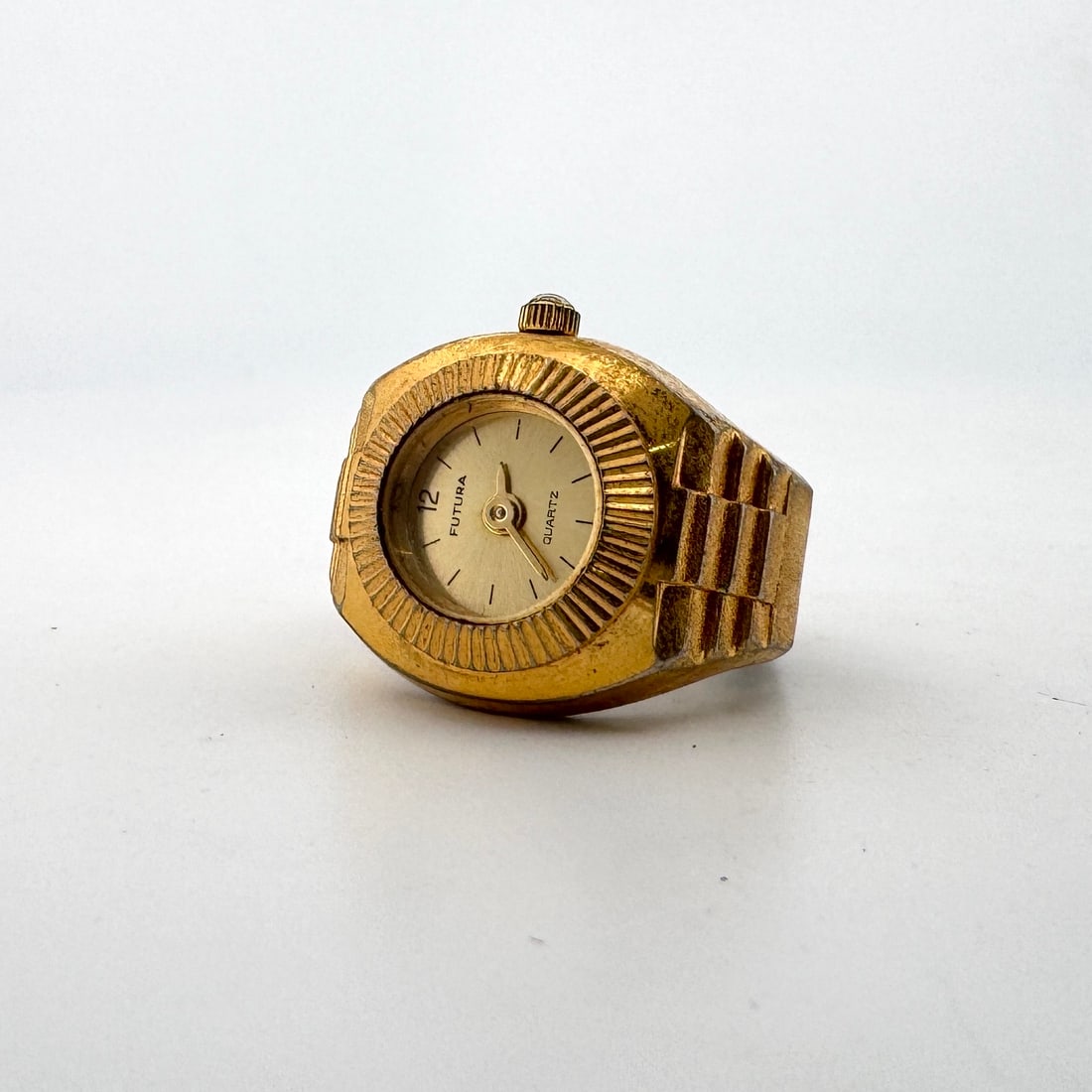 Futura Quartz Ring Watch: A vintage Futura quartz ring watch with a gold-tone finish. The watch features a round dial with Arabic numerals and a flexible metal band. The movement is Swiss, assembled in China. Size: 2.5 x 2.5 c