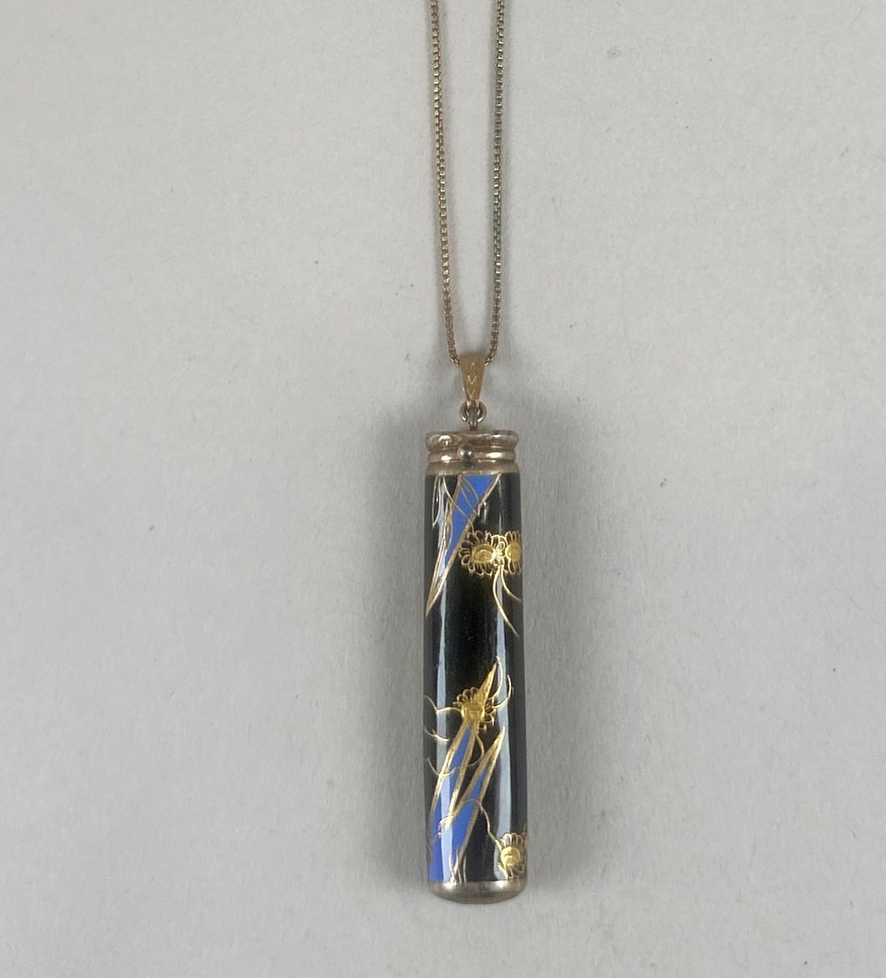 Vintage Sterling Silver Enamel Compartment Pendant Necklace: A vintage pendant necklace featuring a cylindrical black lacquer pendant adorned with intricate gold-tone floral designs and blue accents. The pendant hangs from a delicate gold-tone chain. Weight: