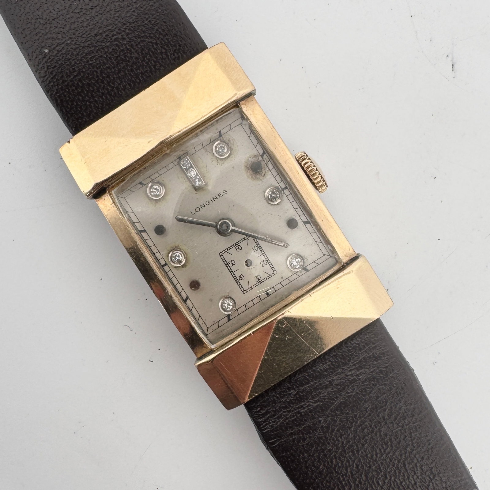 Vintage Longines Diamond Accent Wristwatch: Vintage Longines wristwatch. Gold tone case with diamond accents on the dial. Brown leather band. Weighs 1.1 oz and measures 2 inches long with the band closed. Measures: 9'' approx. with the