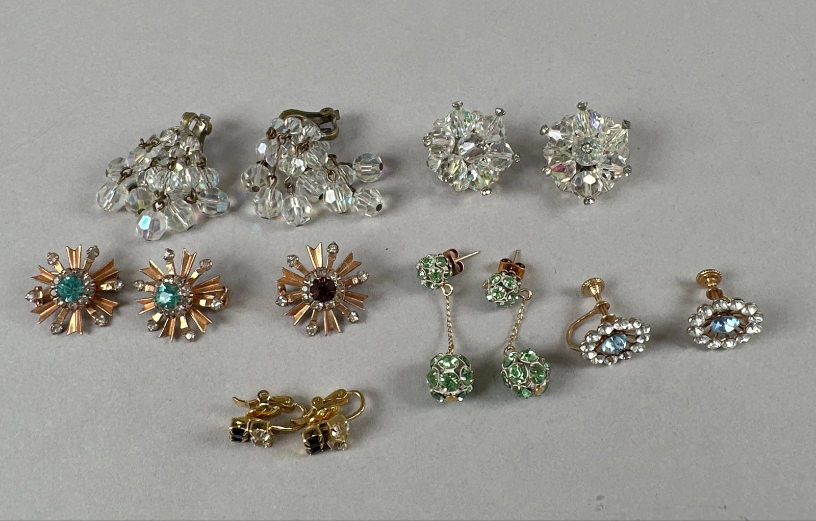 Collection of Vintage Costume Earrings, Trifari: A collection of assorted vintage costume earrings, including clip-on and screw-back styles. Features various designs with rhinestones, crystals, and colored beads. Some pieces are signed Trifari. Weig