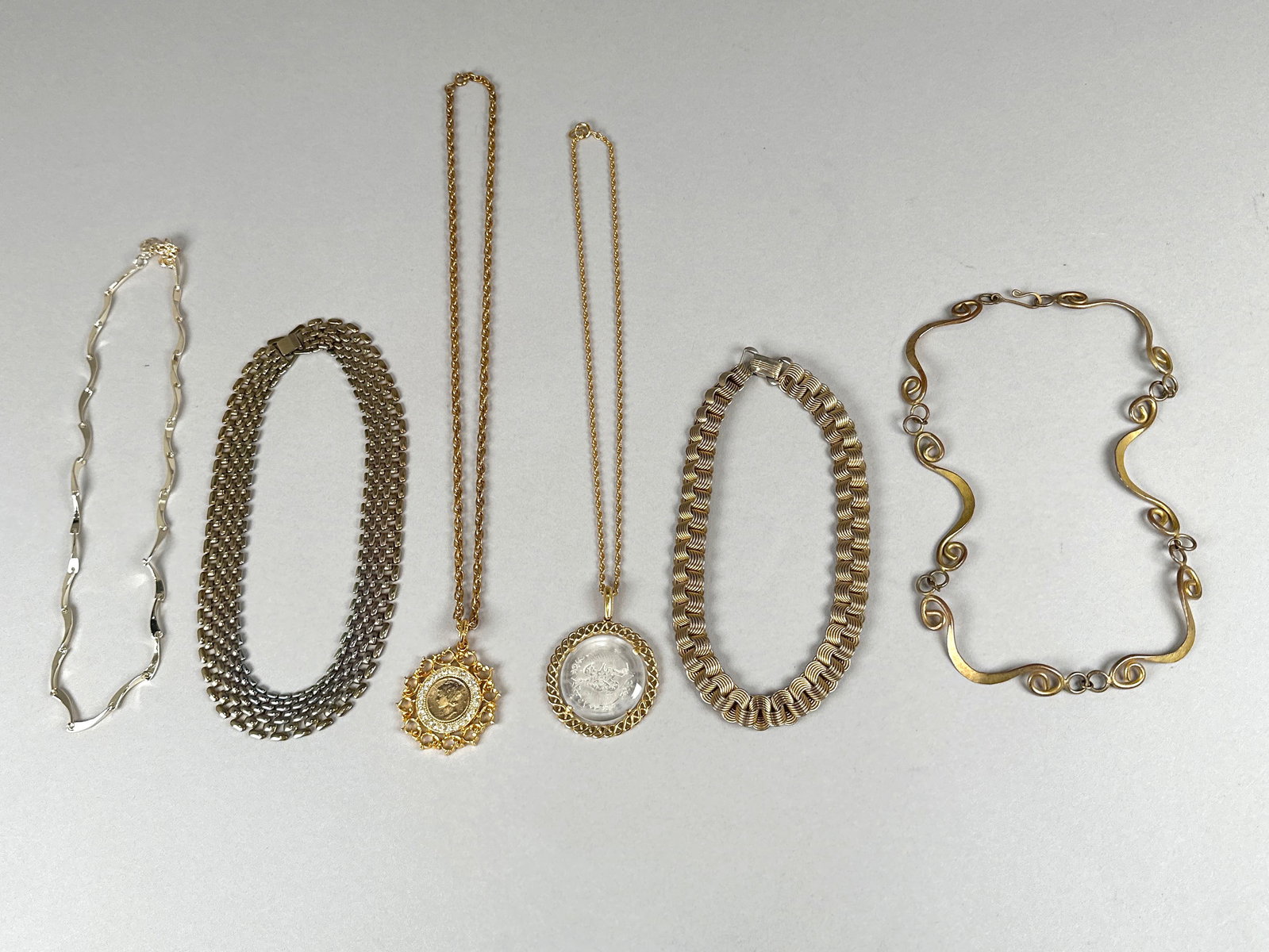 Collection of Vintage Necklaces: A collection of six necklaces, featuring various chain styles, pendants, and metal finishes. Some pieces are marked 'Korea' and 'Rhythm'. Total weight is 234 grams. Longest one: 1