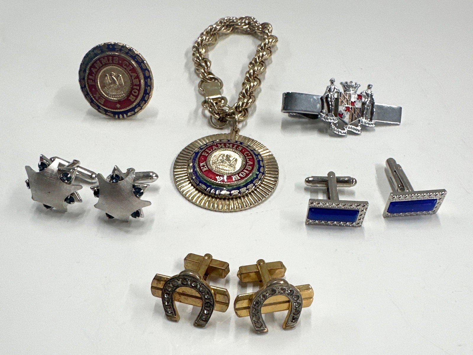 Cufflinks, Tie Bar, & Fire Chief Accessories: This lot features a collection of men's accessories including several pairs of cufflinks, tie clips, and a decorative medal on a chain. Weight: 108g. Largest item: 5''. 