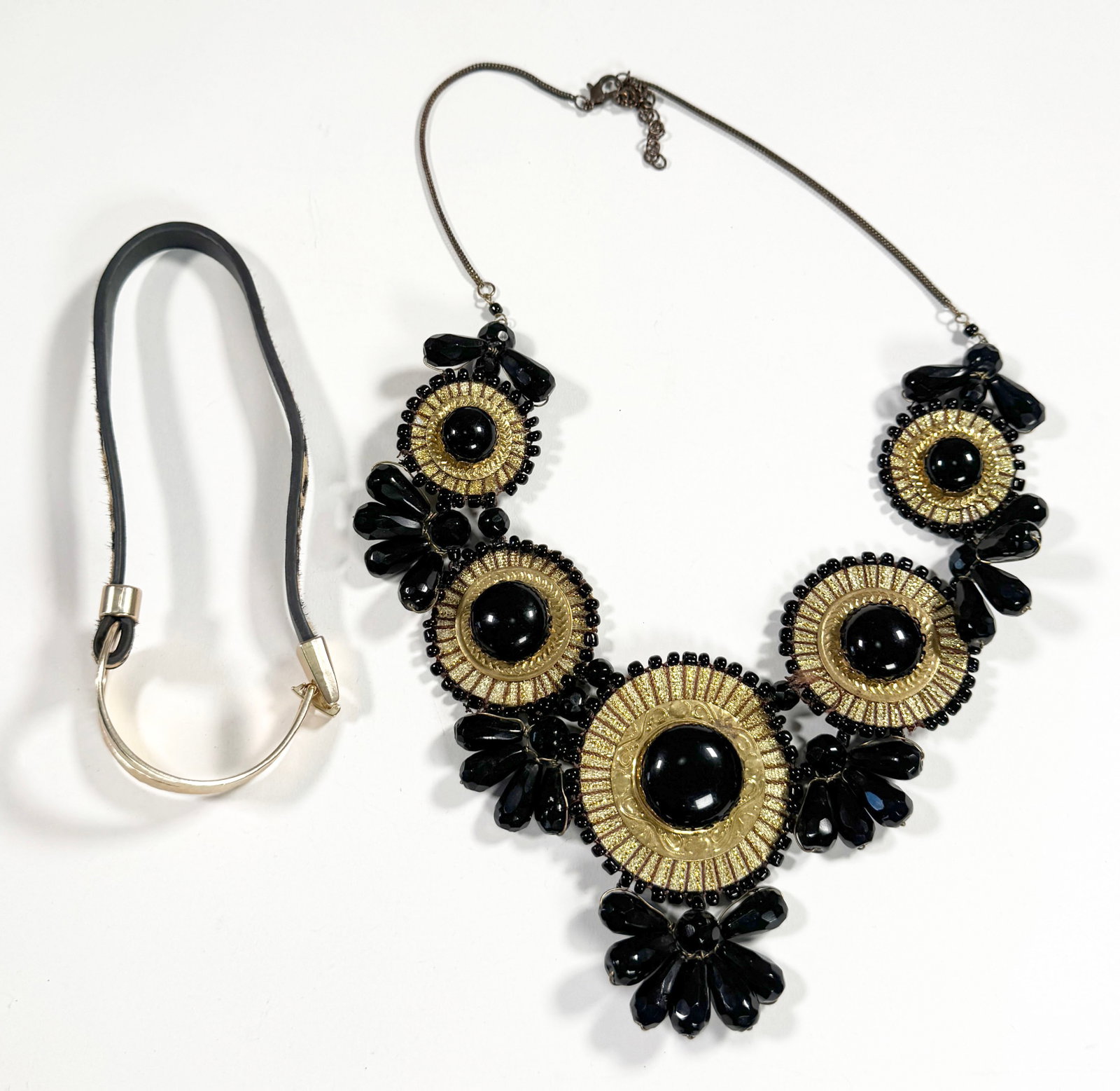 Two Costume Jewelry Necklaces: Includes a black and gold tone floral design necklace and a black choker with gold tone hardware. Necklace is approximately 15 inches long and weighs 5.8 oz.