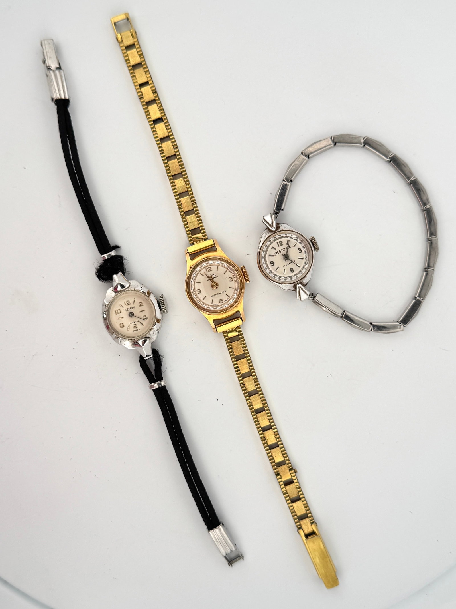 Lot of Three Vintage Ladies' Wristwatches: Oris, Semag, and Westclox: This lot features three vintage ladies' wristwatches. One is a gold-tone watch with a flexible bracelet, marked 'Oris' with '17 Jewels' and 'Anti-Shock'. Another is a