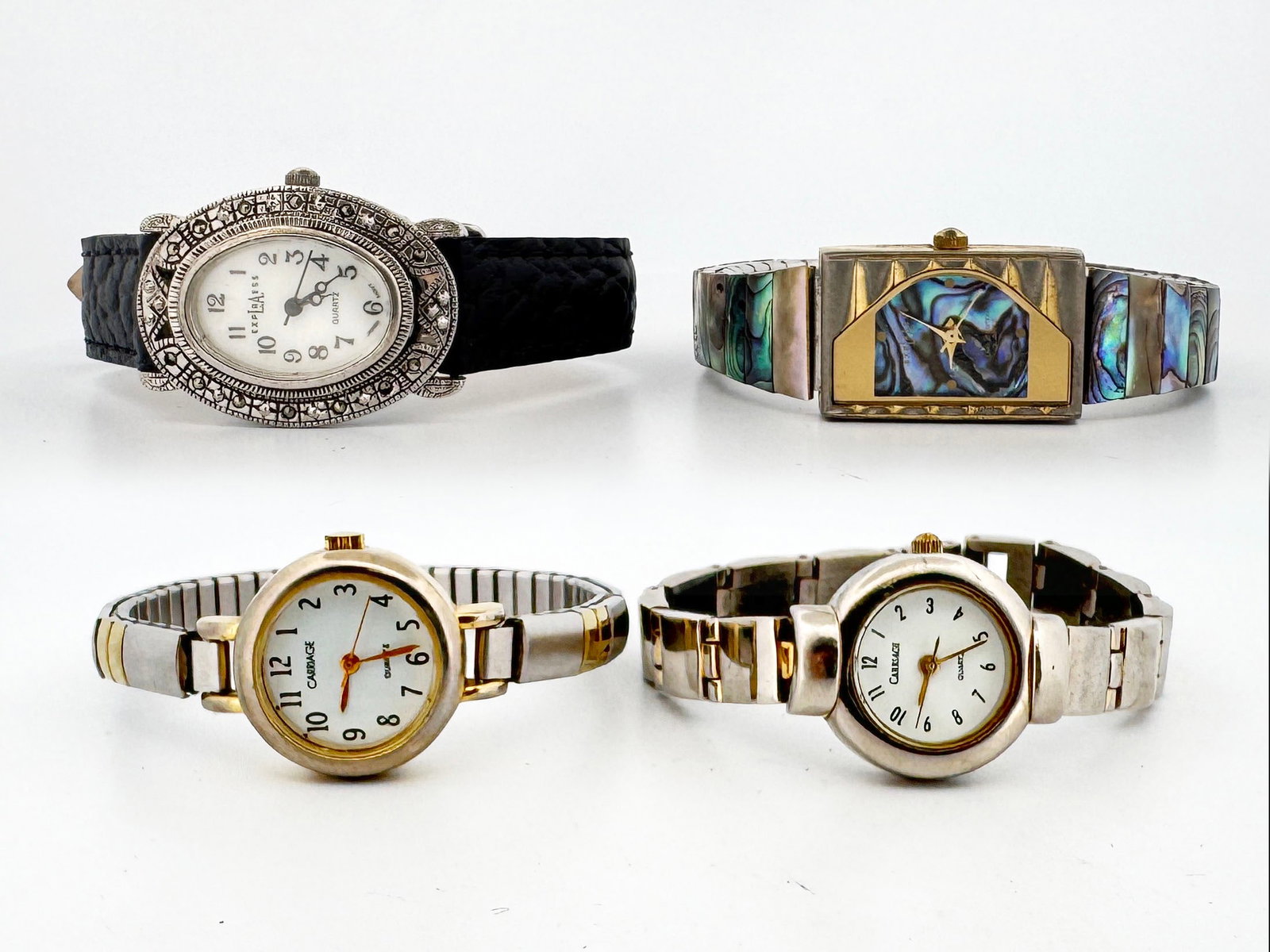 Lot of Four Women's Quartz Wristwatches: This lot includes 4 women's quartz wristwatches. Two are a Carriage with a gold-tone bezel and stainless steel expansion band. Another is an Express watch with a silver-tone oval case, b