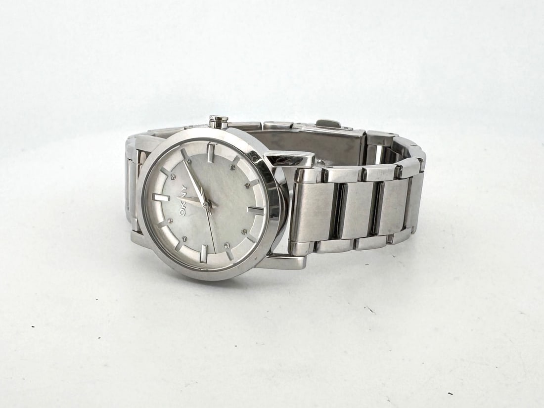 DKNY Stainless Steel Quartz Wristwatch: A DKNY stainless steel wristwatch with a silver-tone dial and metal link bracelet. The watch features a quartz movement and is water-resistant up to 5 ATM. Model number NY-4519.