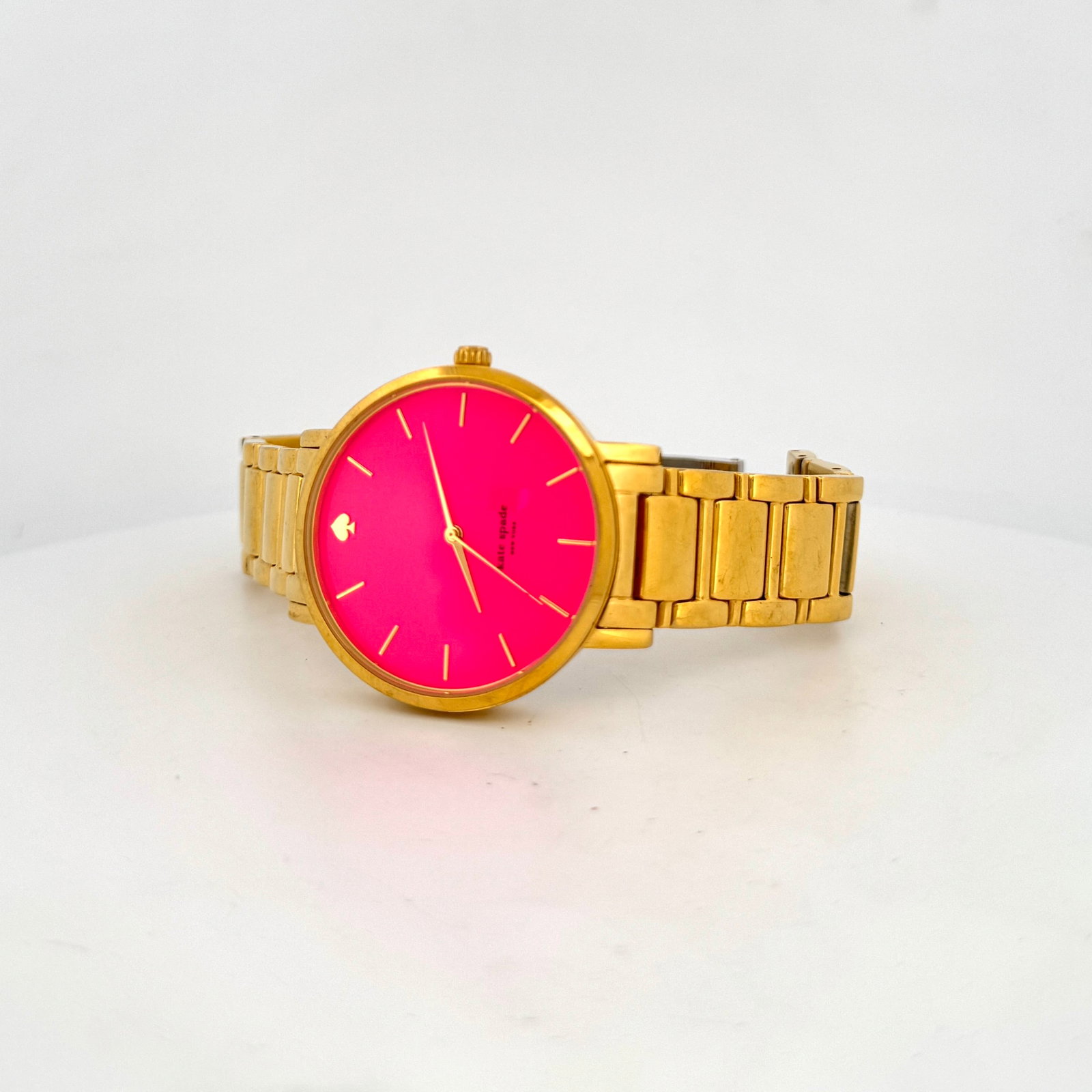 Kate Spade New York Gold-Tone Watch with Pink Dial: A stylish Kate Spade New York watch featuring a vibrant pink dial and a gold-tone stainless steel bracelet. The watch is water-resistant up to 3 ATM. 