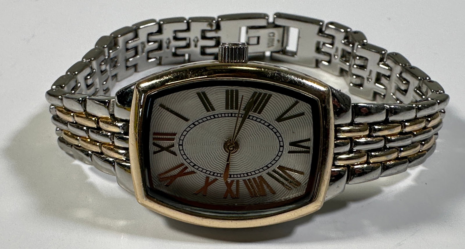 Ladies Two-Tone Fashion Watch: Ladies fashion watch with a two-tone band and a silver-tone face with Roman numeral markers. The watch has a rectangular case with rounded corners. Weight: 1.2oz. Size: 1'' x 2.5''.&nb
