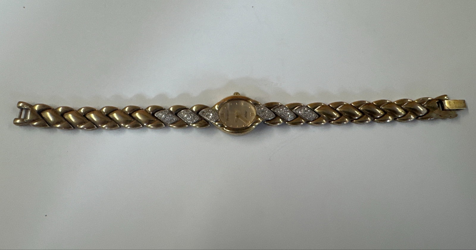 Armitron Now Women's Gold Tone Watch with Crystal Accents: This elegant Armitron Now women's watch features a gold-tone oval case and a braided link bracelet adorned with sparkling crystals. The watch face displays Roman numerals, with the 'Now' l