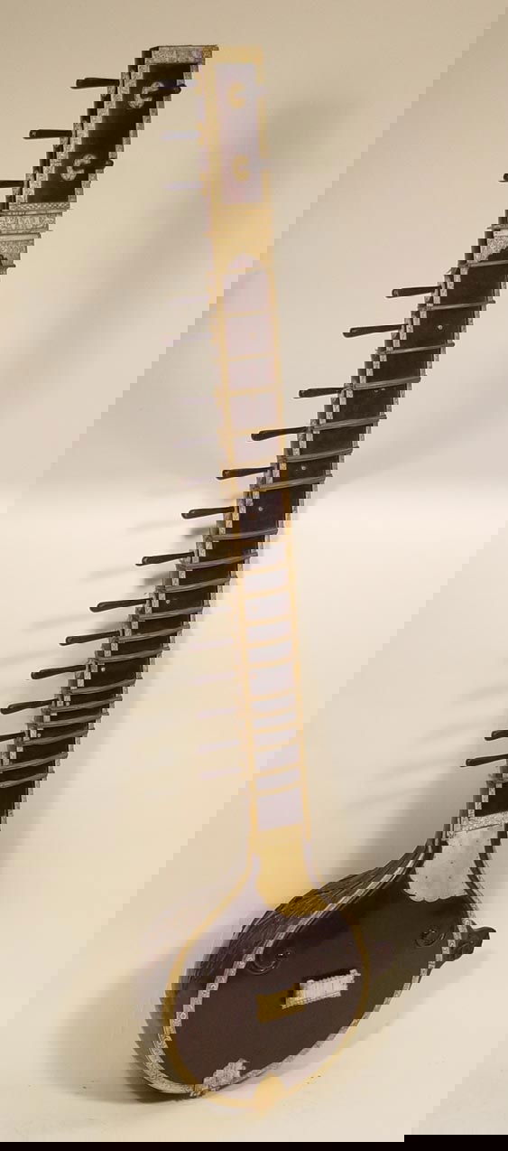 Fine and Early Sitar: ca. 18th-early 19th centuryA somewhat miraculous survival. The body made from a gourd with deep and dramatic floriform carving. The neck with bronze frets attached with silk. Ivory or bone banding all