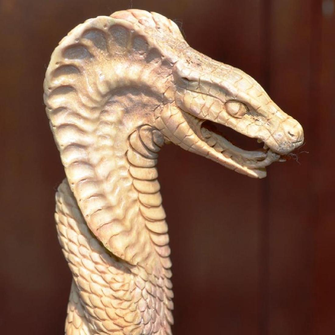 Carved Antler Cobra Snake Can Handle: Hand-carved shed deer antler, in the form of a coiled & striking cobra snake, bearing fangs & forked tongue. 5 1/2" H X 2" W.