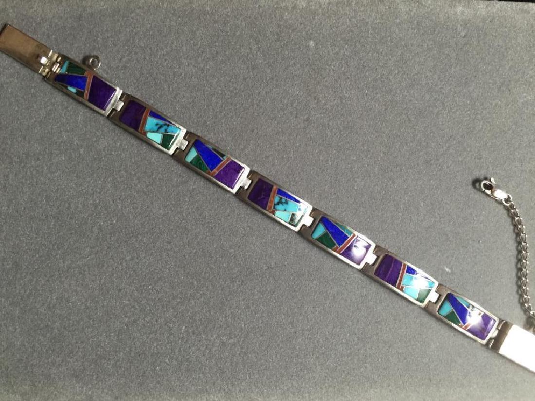 Vintage Navajo Multi Stone Sterling Bracelet: Fantastic vintage Calvin Begay design & also Dine multi-stone inlaid & sterling silver bracelet. Stones include turquoise, oyster, sugalite, onyx & malachite. Safety chain attached. 7 1/2" L.