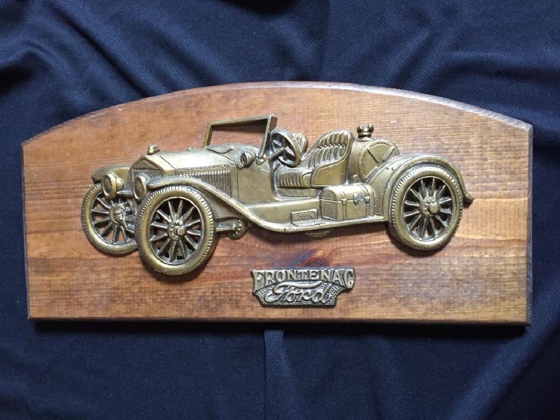 Ford Frontenac Wall Plaque Decoration: Vintage wall plaque decoration. Brass tone metal bas relief of an antique Ford Frontenac car mounted on a wooden plaque. 7" H X 15" W X 3/4" thick.