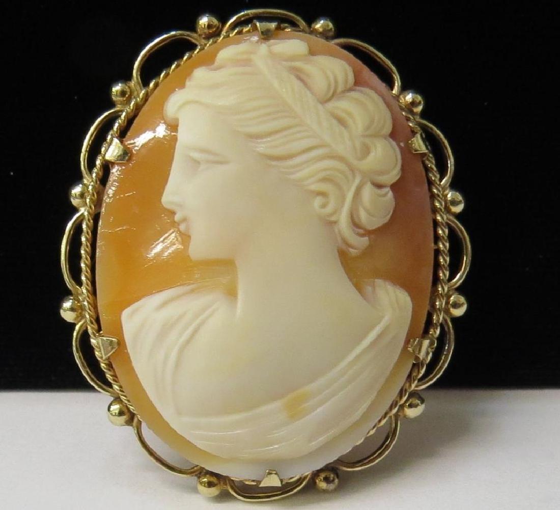 9kt Gold Carved Carnelian Shell Cameo Brooch: Antique 9kt yellow gold, carved carnelian shell cameo brooch. Jeweler's mark on reverse. Small loop in back to covert to a pendant. 1 1/2" diameter.