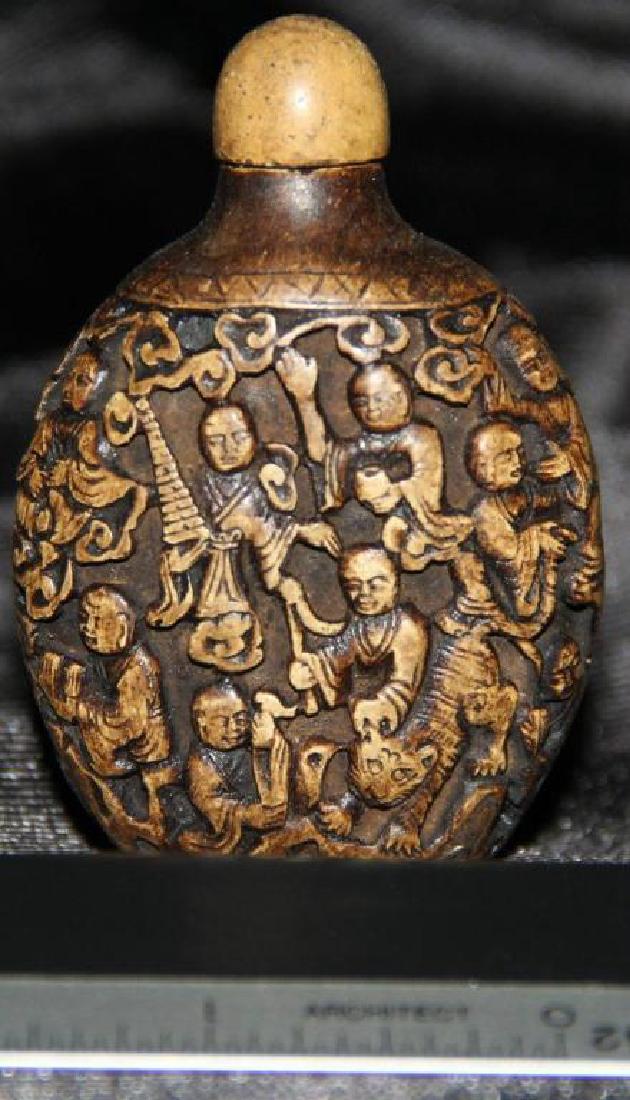 Chinese Hand-carved Stone Medicine Snuff Bottle: Intricate hand-carved scene depicting a variety of Buddhist monks, with a fire breathing dragon on one side & a tiger on the reverse. 2.75" H X 1 3/4" W X 1" thick.