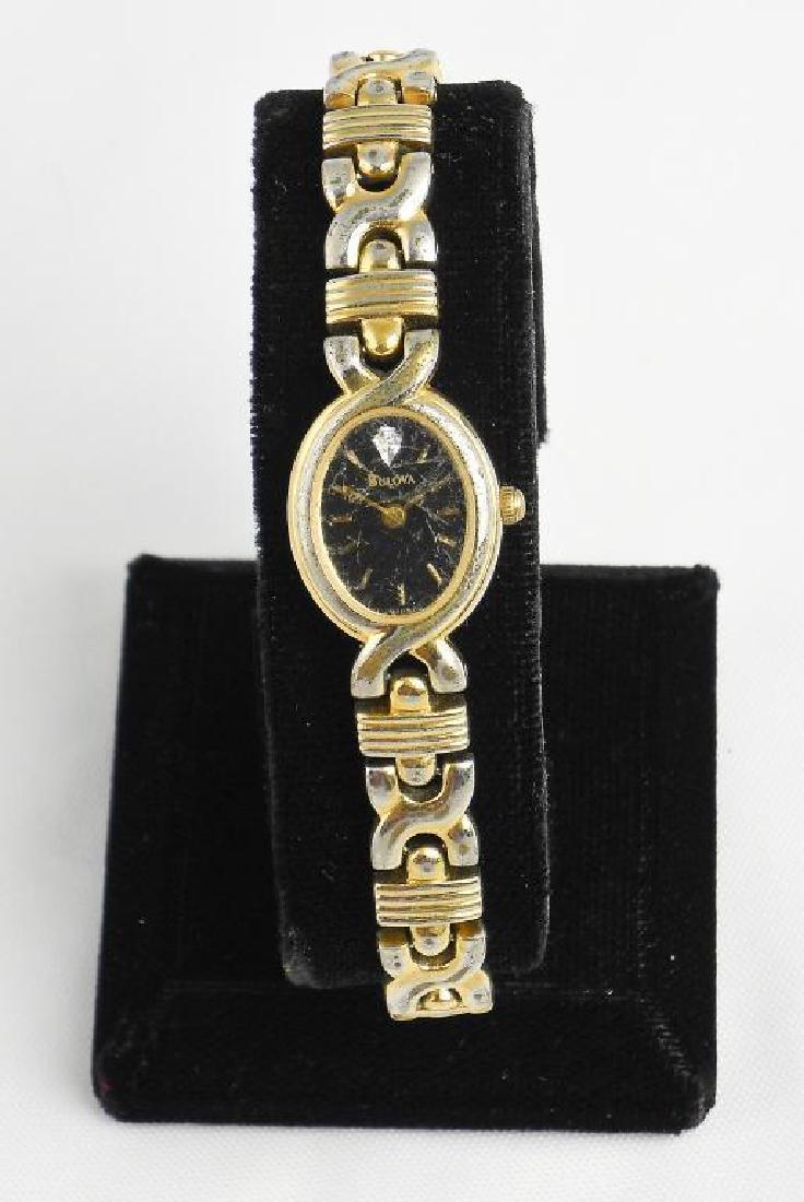 Vintage Ladies Bulova Quartz Wristwatch: Vintage ladies Bulova gold fashion wristwatch with black face dial, gold notch notches for numerals & gold hands. A quartz crystal as the 12 O'Clock marker. Thin bracelet link band. Needs repair. Sold