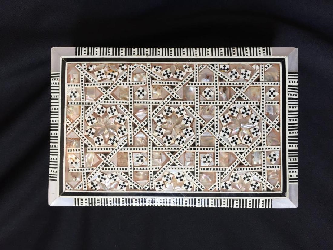 Mother Of Pearl Inlaid Jewel Trinket Box: Egyptian beechwood rectangular box, inlaid with intricate geometric mosaic pattern, hand cut slivers of mother of pearl abalone shell. Velvet lined interior. 4 1/4" D X 6 1/2" W X 2" H. * tiny chip mi