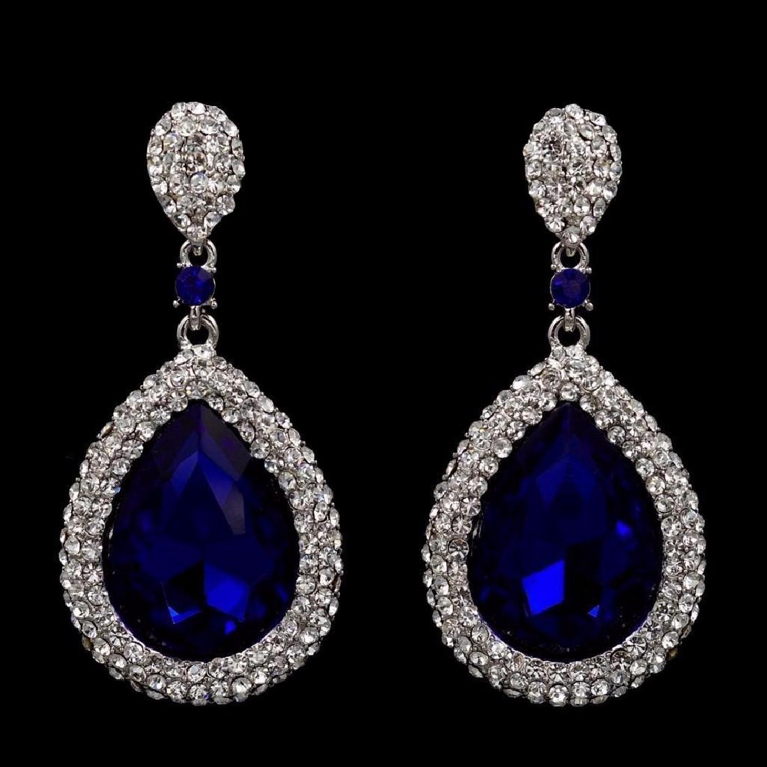 Swarovski Crystal Rhinestone Costume Jewelry Earrings: Sapphire Blue Czech pear shaped focal crystals, surrounded by clear rhinestones, set into drop dangle, rhodium plated earrings. 2 1/4" L.