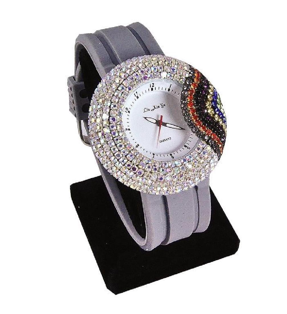 Girl's Rainbow Rhinestone Watch: Colorful rhinestones surround the face of the watch, forming a rainbow at the side. Gray silicon sports band. Analog display & quartz movement. Store display in need of battery replacement.