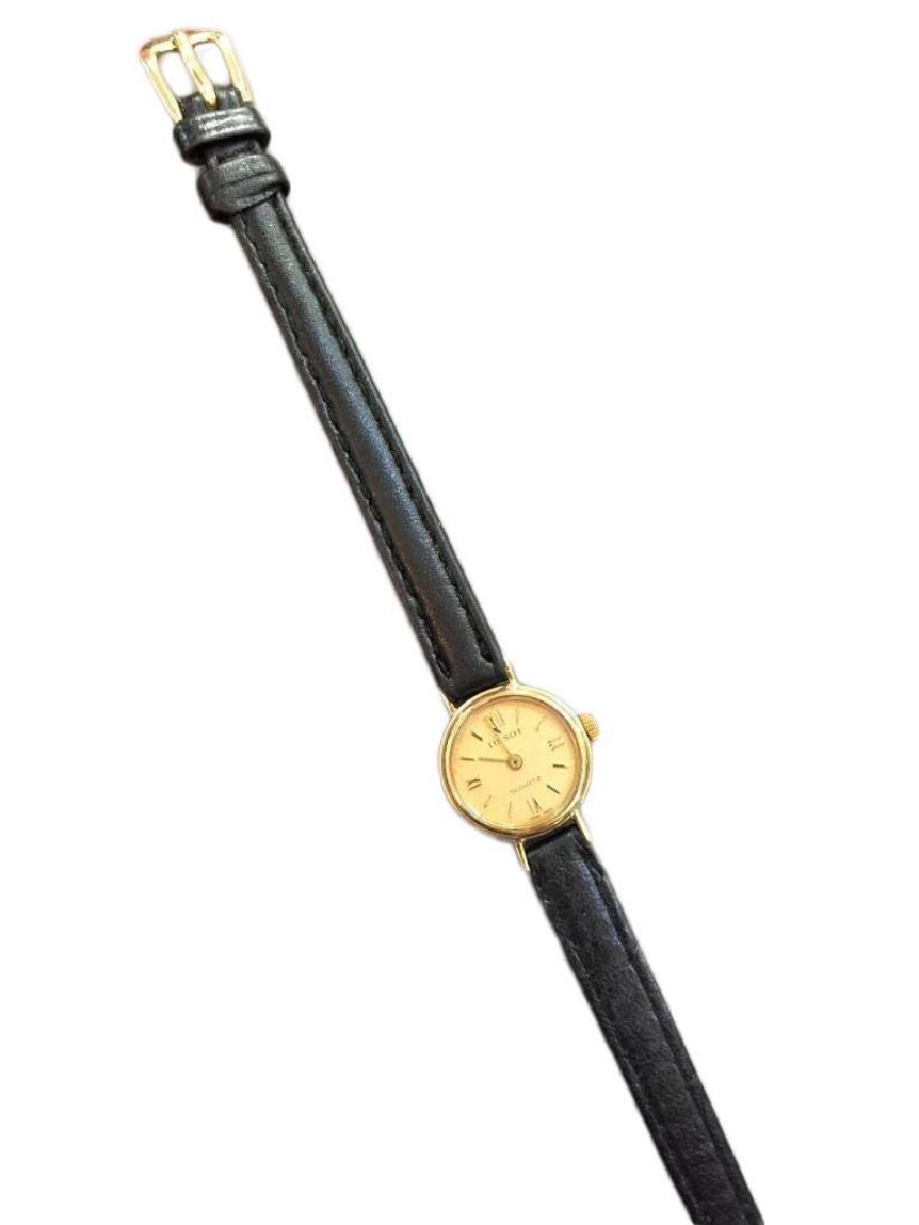 Ladies 9kt Gold Tissot Luxury Wristwatch: Vintage ladies 9kt gold quartz Tissot wristwatch. Gold case & face with Roman numerals. 3/4" D. Black leather strap.