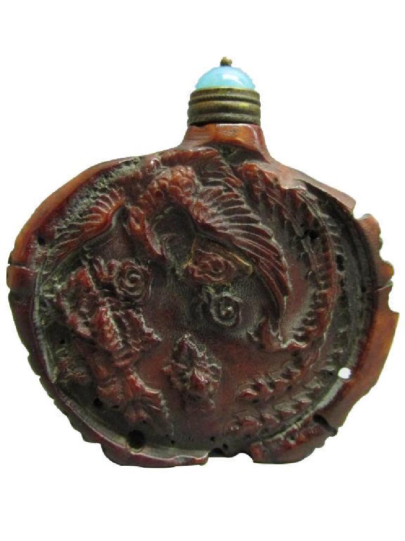 Antique Hand-carved Ox Horn Phoenix Snuff Medicine: Gorgeous, reddish-brown antique hand-carved ox horn snuff bottle with phoenix design. Blue colored glass or stone top with brass surround & brass spoon in tact. 2 1/2" W X 2 1/2" H X 1/2" D. The P