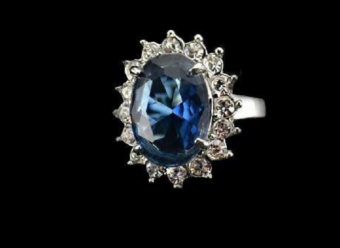 Princess Diana Style Blue Crystal Cruise Ring: "Princess Diana style, large oval faceted sapphire blue Swarovski crystal, surrounded by smaller round faceted clear crystals, set into a silver metal setting. Size 6