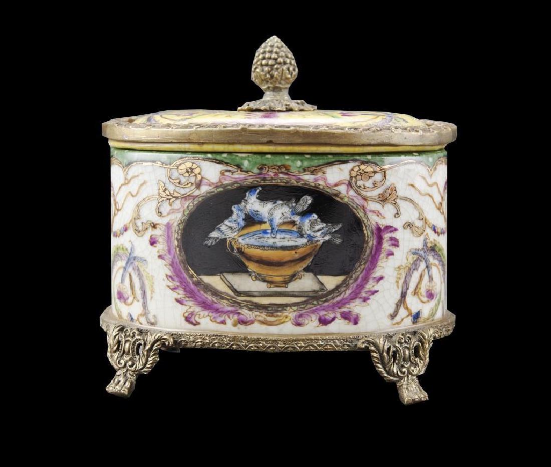Porcelain & Bronze Bird Trinket Box: Bronze footed porcelain trinket, jewel or tobacco box casket. Hand painted scene of birds at their bath. Acorn finial. Gold gilt highlights towards the rim. 3 1/2" H"X 5" L X 3 1/2" W.