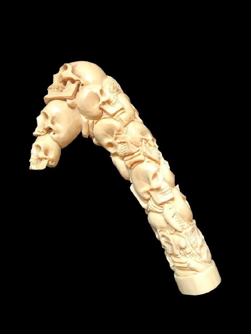 Carved Shed Antler Roman Catacomb Skeleton Skulls Cane: Hand-carved shed deer antler, in the form of stacked skeleton skulls, after the Roman catacombs. Walking stick or cane handle sculpture. 6" L X 3" D X 1 1/4" W.