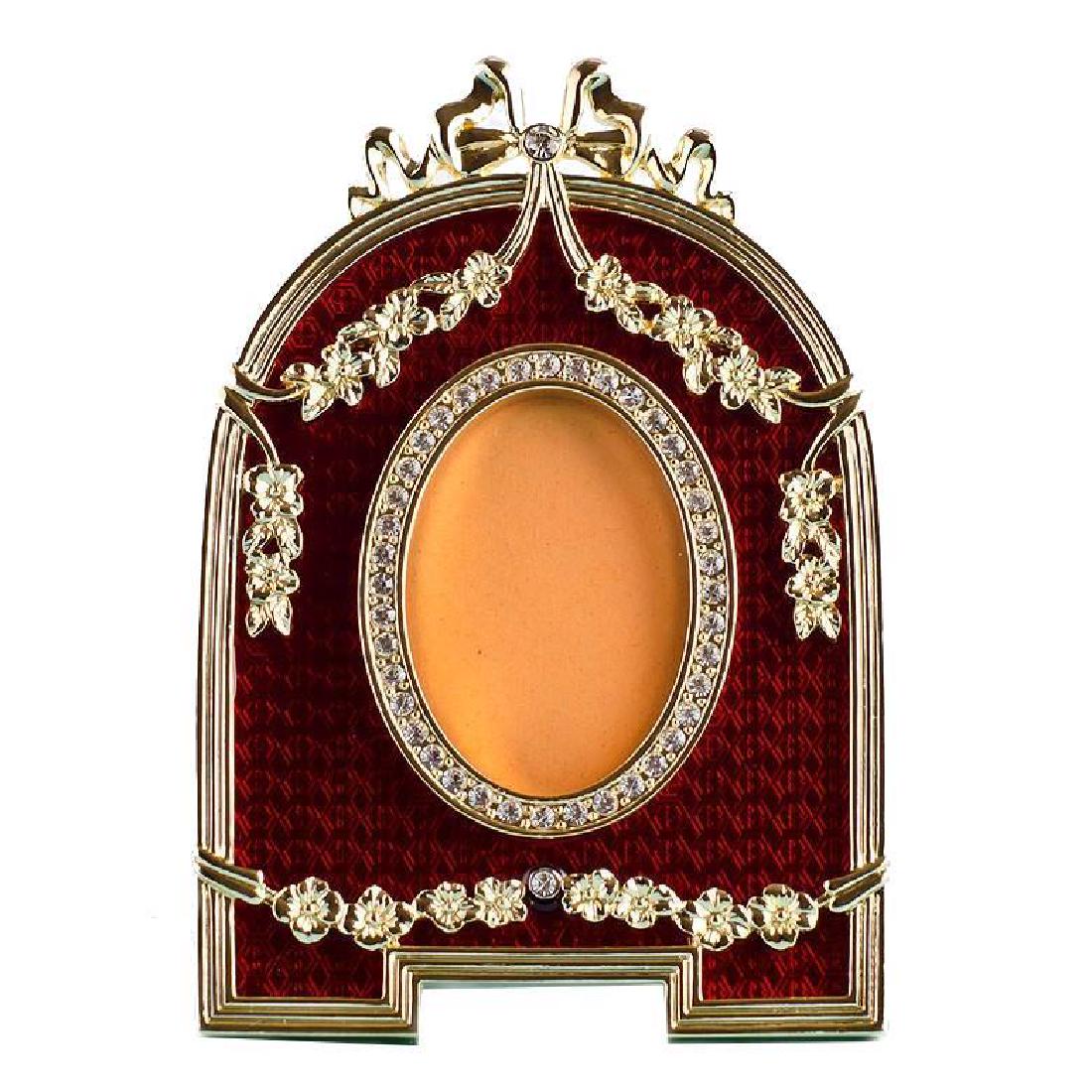Red Enameled Semicircular Russian Royal Picture Frame: Red Enameled Semicircular Faberge Picture Frame Features:Dimensions: 5'' (H) x 3.5'' (L)Photo Opening Dimensions: 2" (H) 1.25" (W)Pewter, Enamel, Crystals Gift Boxed Faberge Eggs have a remarkable sto