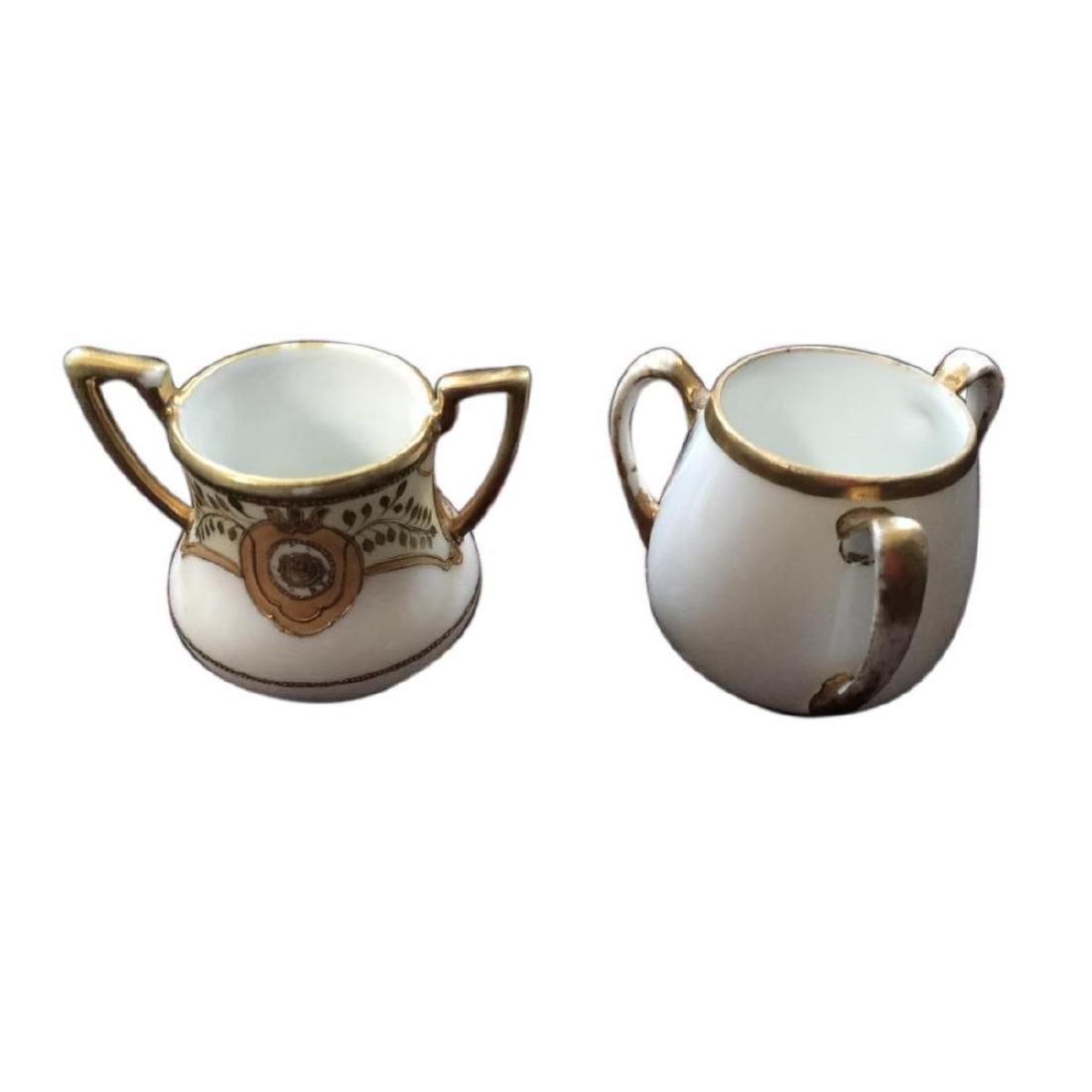 Vintage Pair of Nippon Gold Gilt Toothpick Holders: Vintage hand-painted Nippon china toothpick holders ; a three footed, handled urn with gilt rose & vine embellishment, "Hand Painted, Nippon" stamp on the bottom ( 2 1/2" X 2 7/8" ) & a three handled