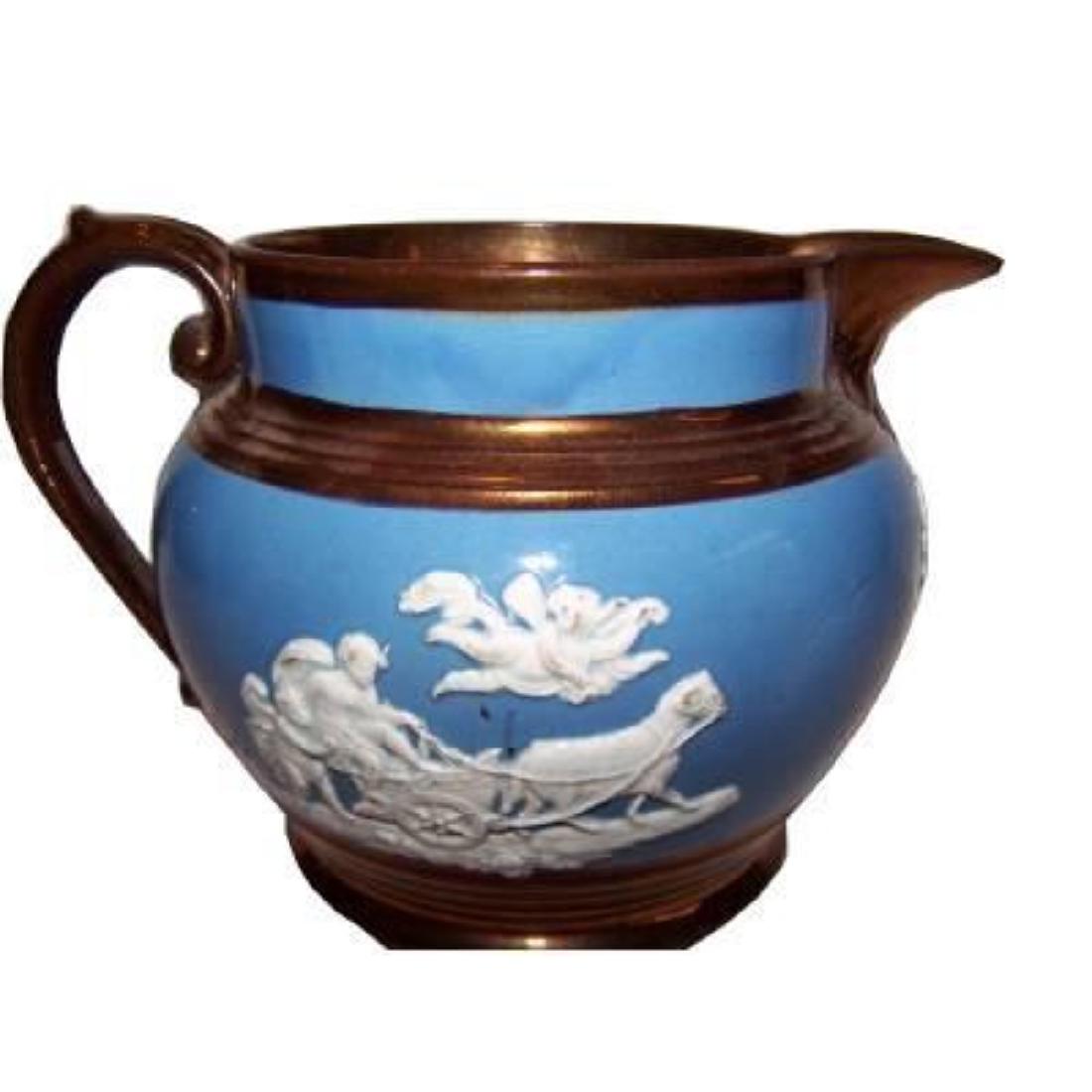 19thc Staffordshire Cherub Copper Lustre Pitcher: Antique 19thc Staffordshire copper lustre cherub putty pitcher, in excellent condition for a 150 year old item. Relief scenes on each side depict cherubs & chariots pulled by goats. The piece has notb