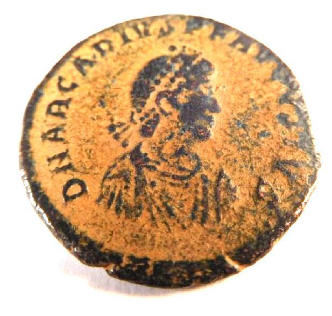 Bronze Coin of Arcadius (383-408 A.D.): The reverse on this coin features the emperor literally stepping on a child sized captive, reading VIRTVS EXERCVIT "the courage of the army". Arcadius was born on New Years Day of 377 A.D. He was the 