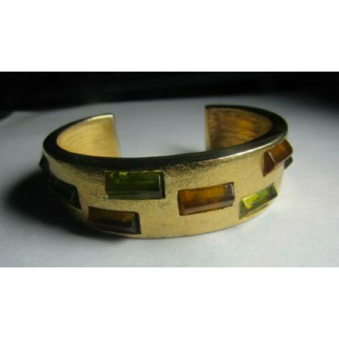 Vintage Givenchy Cuff Bracelet: Vintage French designer, Givenchy, gold tone metal cuff bracelet with green & gold embedded glass jewels. Stamped Givenchy inside. 2" X 2 1/2". 1.5oz.