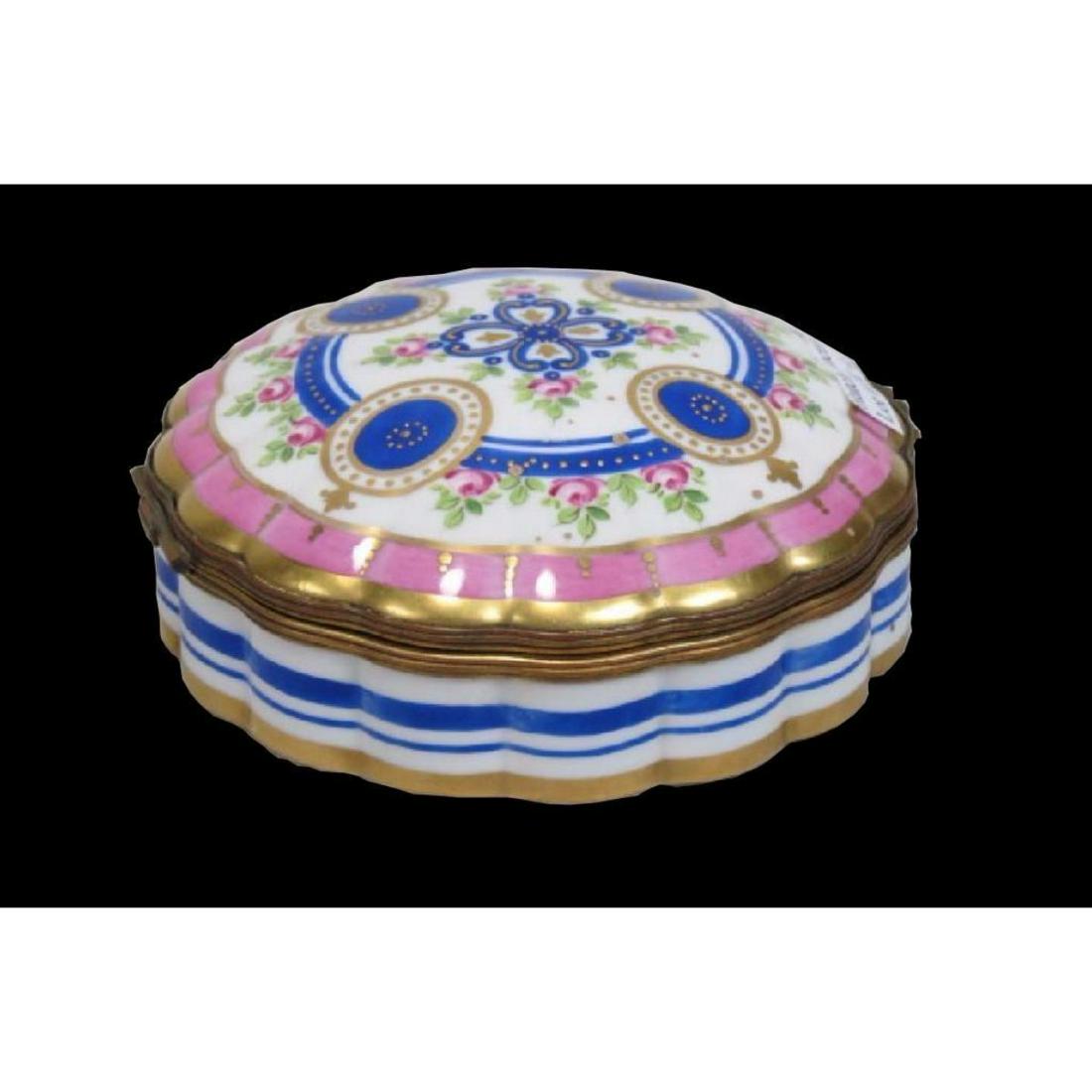 French Porcelain Hand Painted Dresser Box: French porcelain hand-painted dresser box accessory, hinged with ormolu mounts, floral designs painted on a scalloped shape. Signed on bottom, "Made in France". 5" D.Â