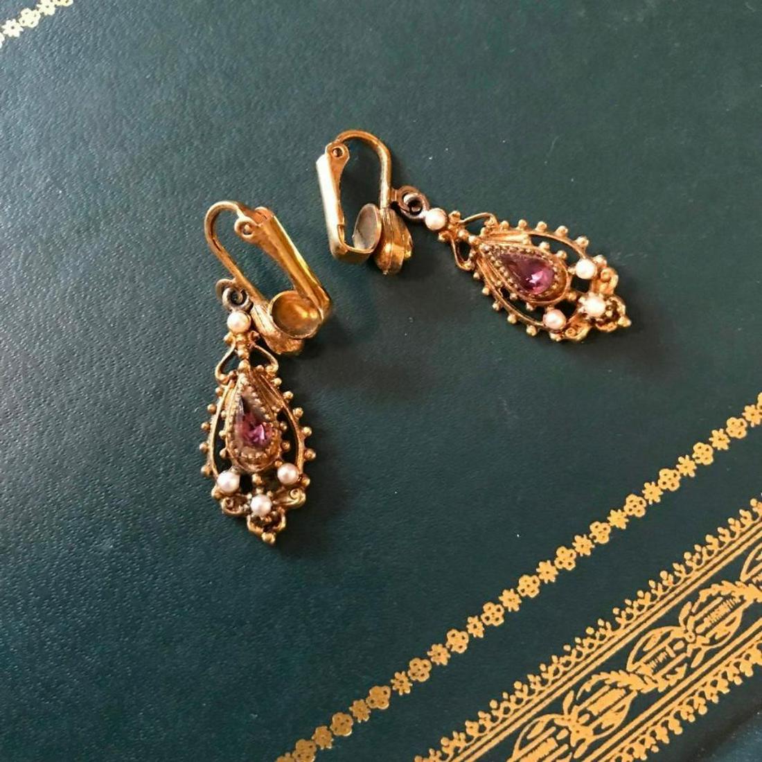 Edwardian Gilt Metal Paste Pearl Earrings: Antique Edwardian pinch-back type yellow gilt metal earrings with repousse decoration with amethyst colored gemstone pastes & saltwater seed pearl accents. 1 1/2" L.