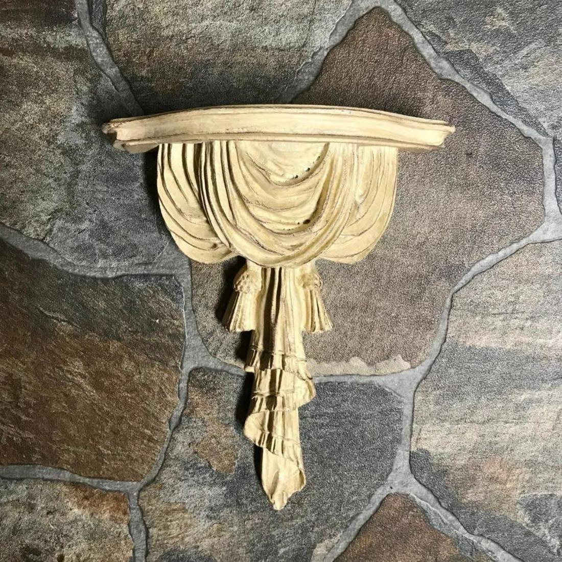 Bone Colored Draped Composite Wall Shelf Bracket: Bone-colored, draped ribbon-style, lightweight composite wall shelf bracket. 12" H X 9" W X 4 1/2" D.