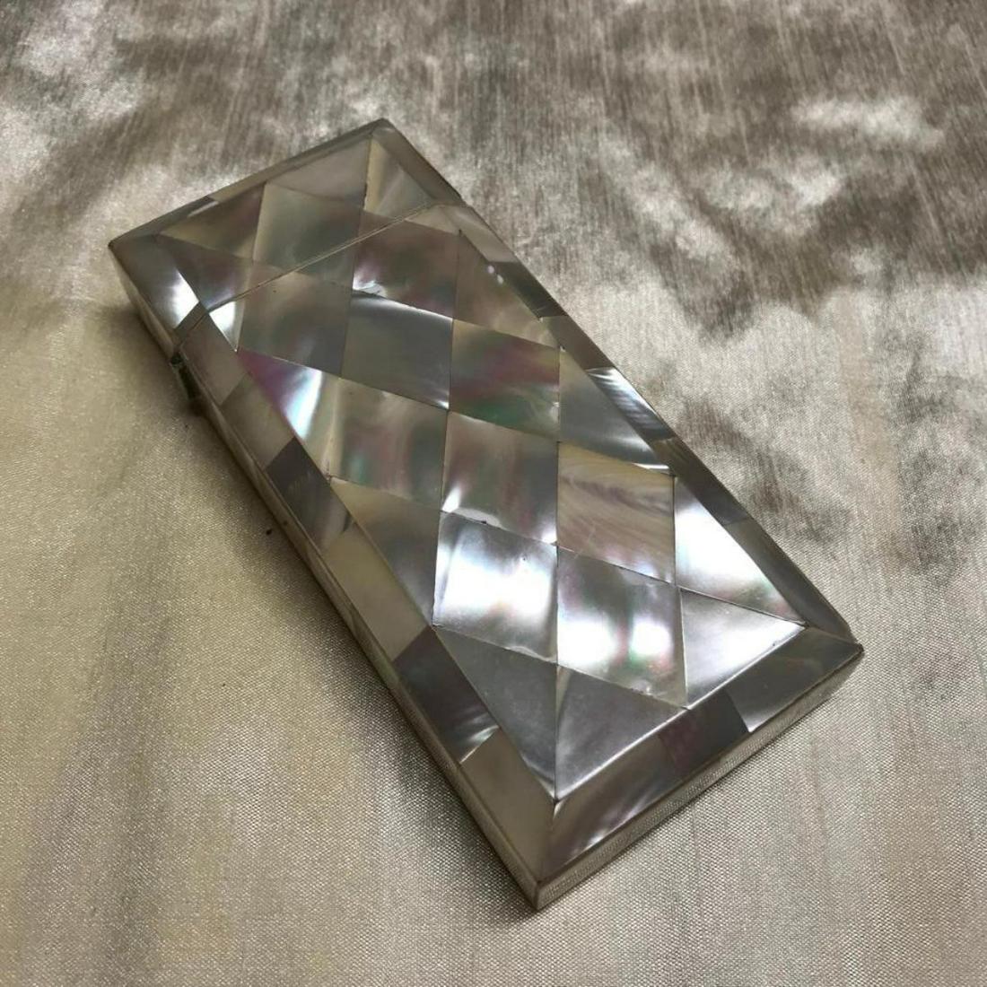 Art Deco Era Mother of Pearl Cigarette Case: Early 20th Century, Art Deco era, cigarette case inlaid with mother of pearl. 2 1/4" W X 5"H X 1" thick. Could also be used as a lipstick case. 1/2" W X 3 1/4" HÂ interior space when lid is open.Â�